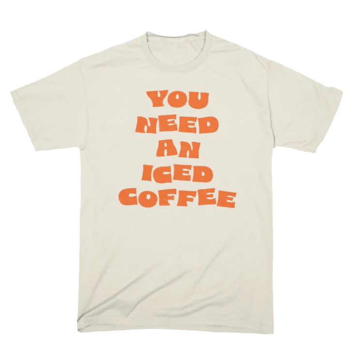 A white T-shirt with the phrase "You Need an Iced Coffee" printed in orange, bold, stylized font.