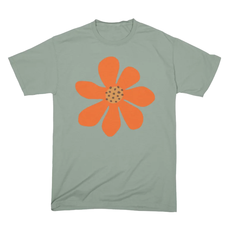 A light green T-shirt with an orange flower graphic on the front, featuring a polka-dotted center and seven petals.