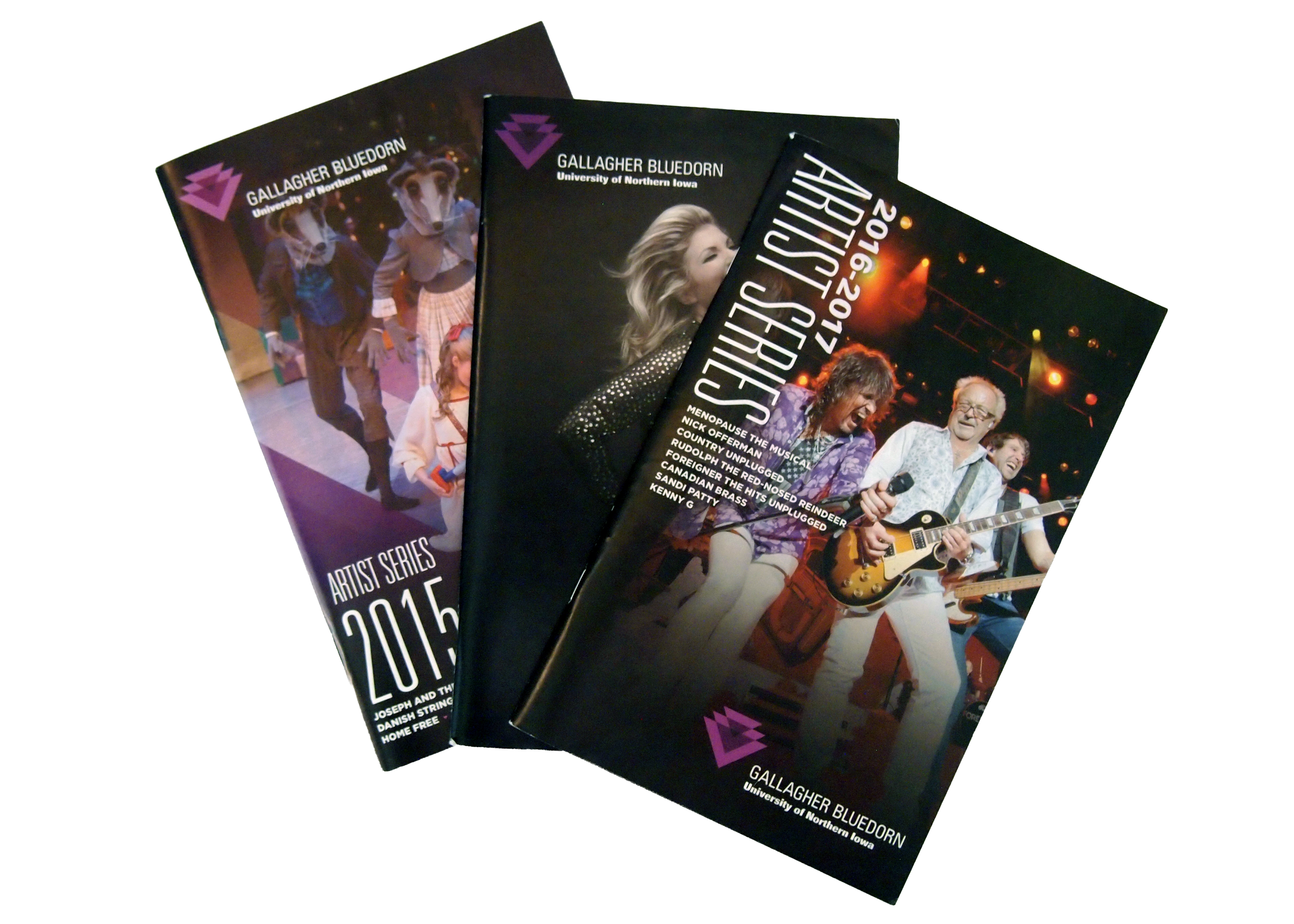 A stack of event programs for the Gallagher Bluedorn University of Northern Iowa with images of performers on stage, including a man playing guitar and singing, and a group of children in costumes.