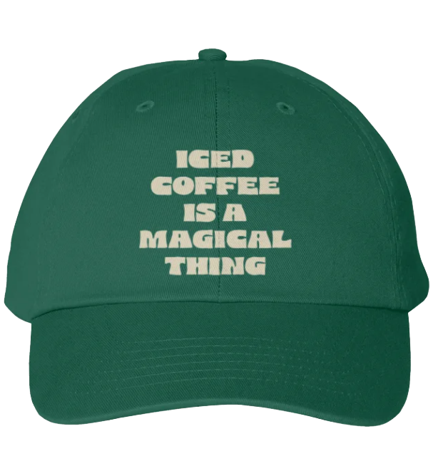 Green baseball cap with white embroidered text reading "Iced Coffee Is a Magical Thing"