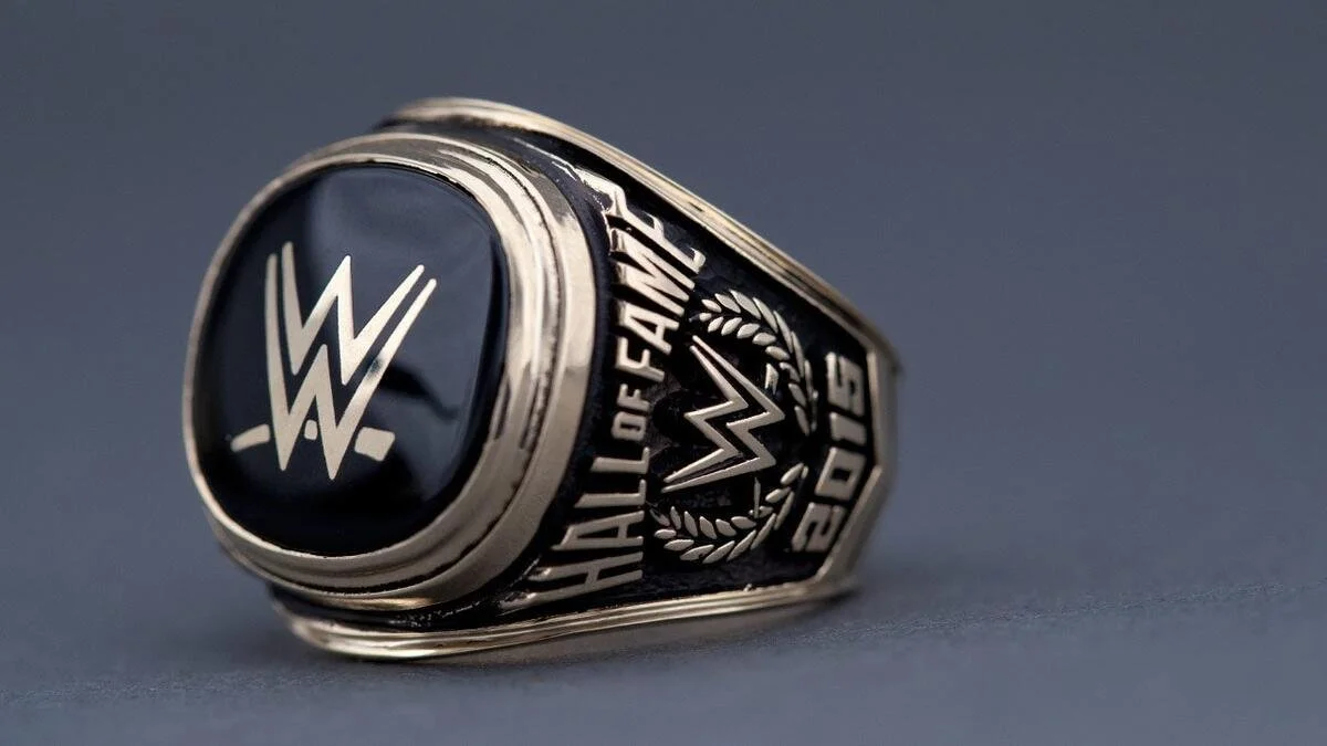 A black and silver wrestling championship ring with a WWE logo on top and engraved details on the sides.