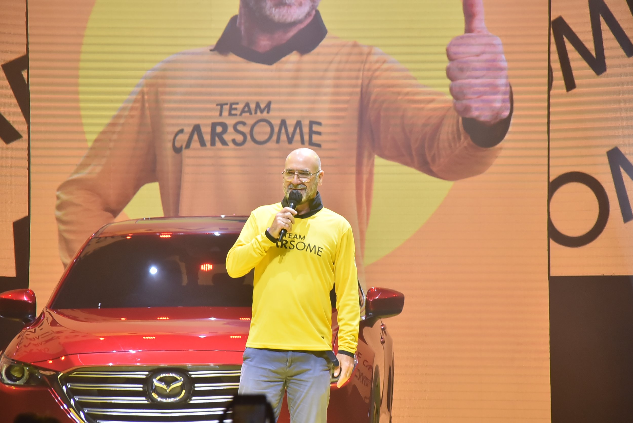  Eric Cantona, Brand Ambassador CARSOME, menyambut media dan tamu undangan lainnya di panggung acara peluncuran CARSOME Certified Lab di Cakung, Jakarta Timur pada Kamis, 8 September 2022 