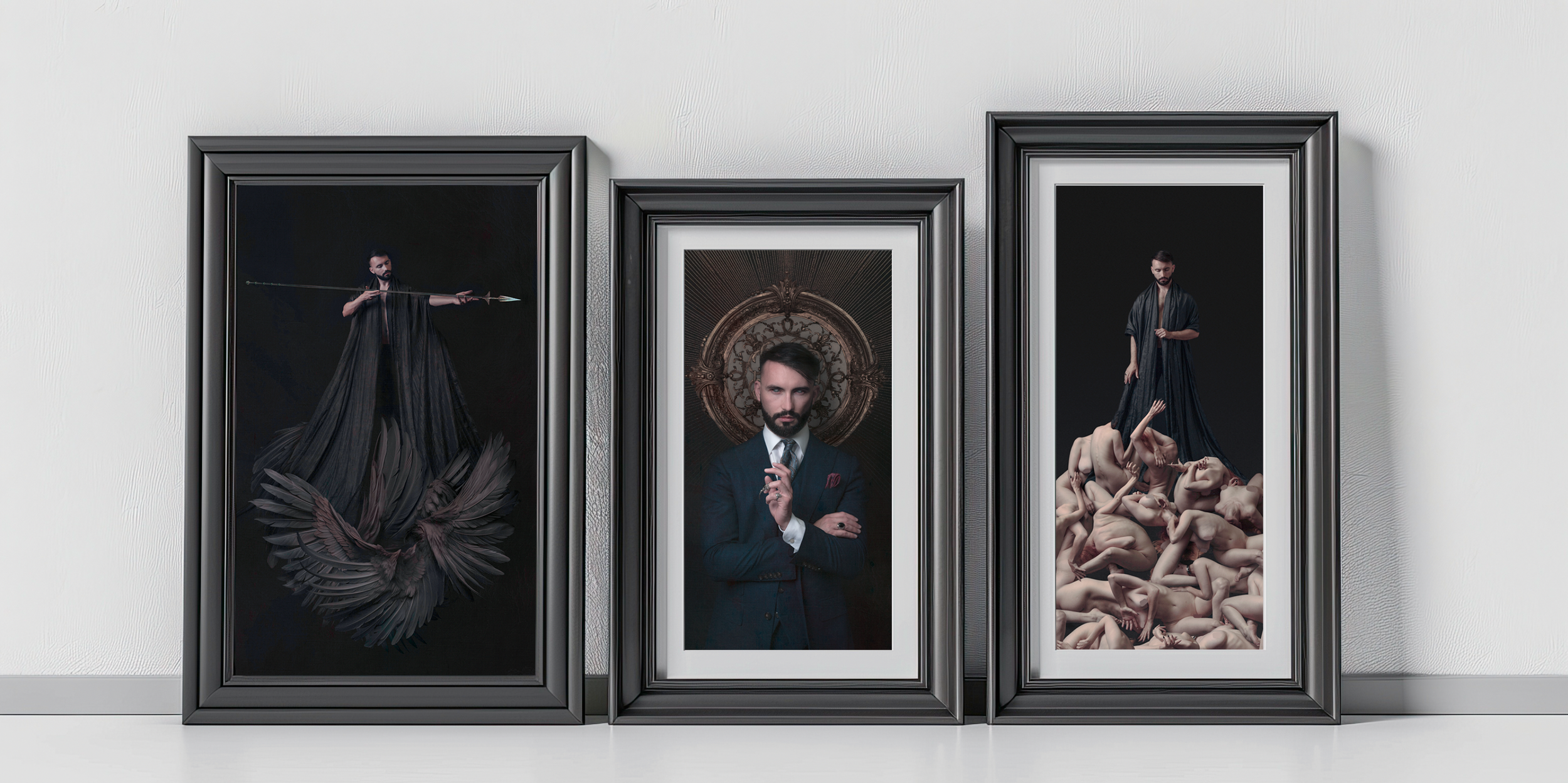 Three framed portraits leaning against a white wall. The left portrait shows a man holding a spear, dressed in black with a dark background. The center portrait features a man in a suit standing before an ornate, round mirror with a decorative frame. The right portrait displays a man in dark clothing standing among numerous nude, intertwined bodies on a black background.
