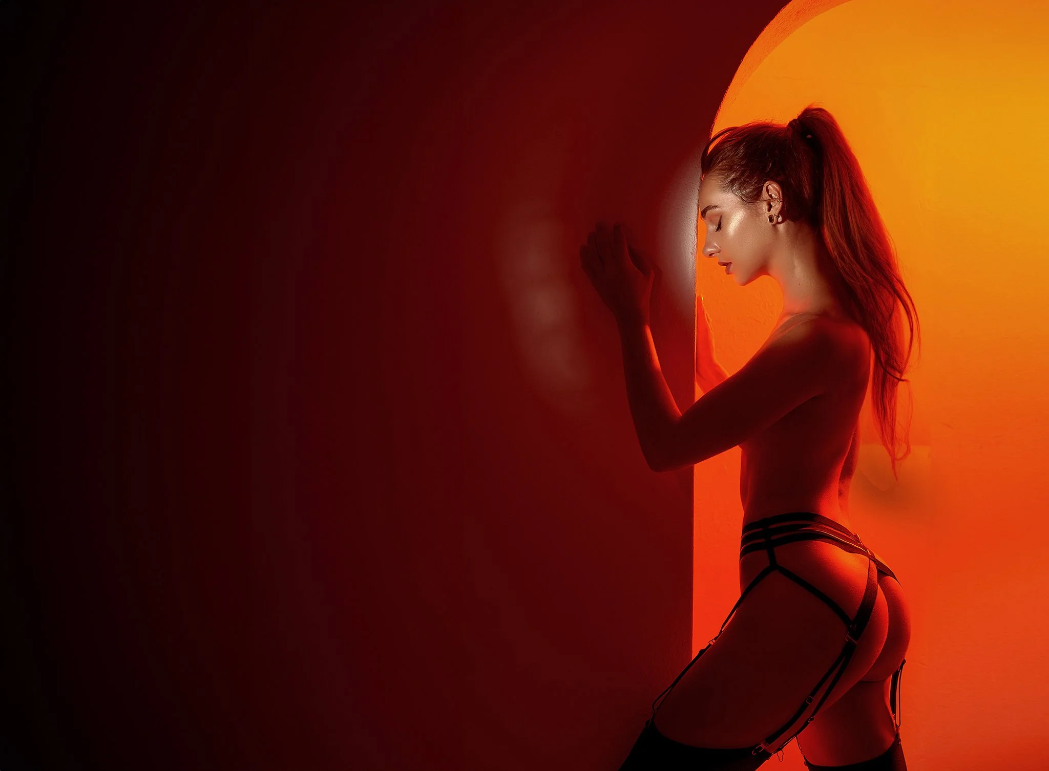 Cinematic boudoir portrait in red light — intimate, bold, and unapologetically feminine.