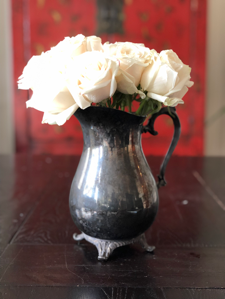 While roses in a vintage silver pitcher.png