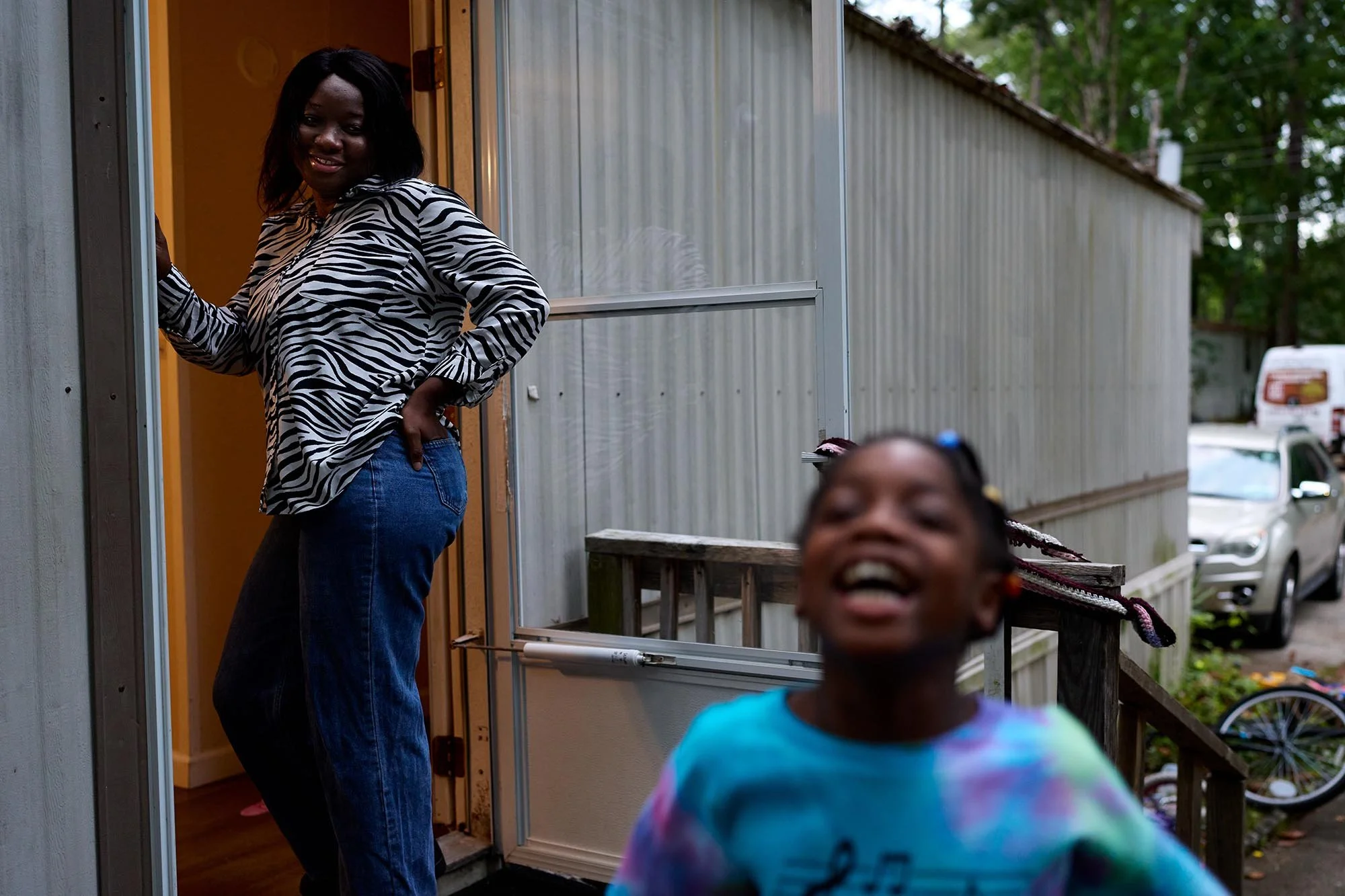 Abigael Dawah watches her daughter, Lydie, play outside their home in Chatham Estates. The trailer park was bought by a billionaire developer and all the residents were told to leave in 6 months. (for INDY Week)