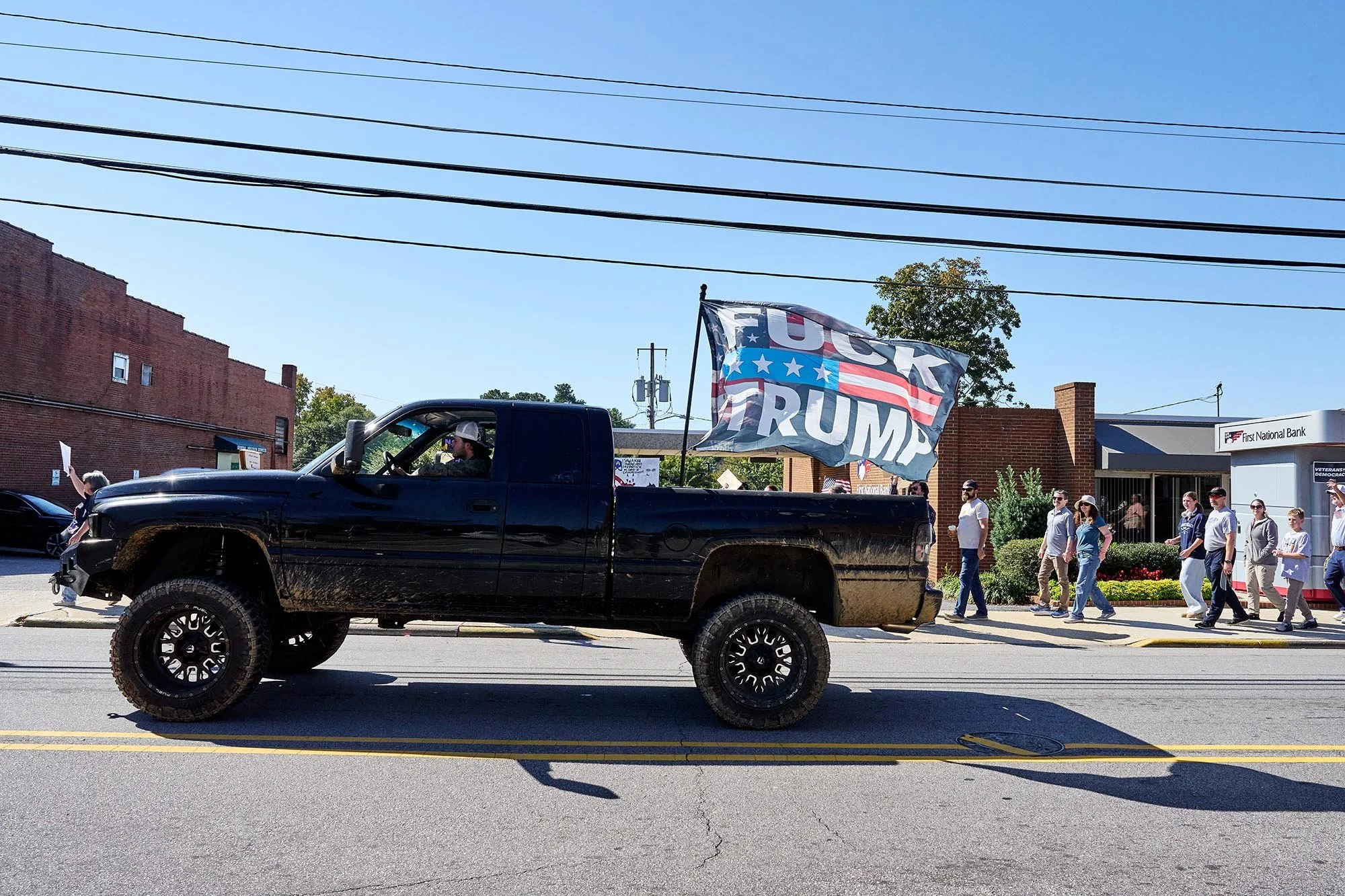 Joseph Greer drives his lifted pickup truck with a large "Fuck Trump" flag during the No Kings rally in Clayton, NC. (for WUNC/NPR)