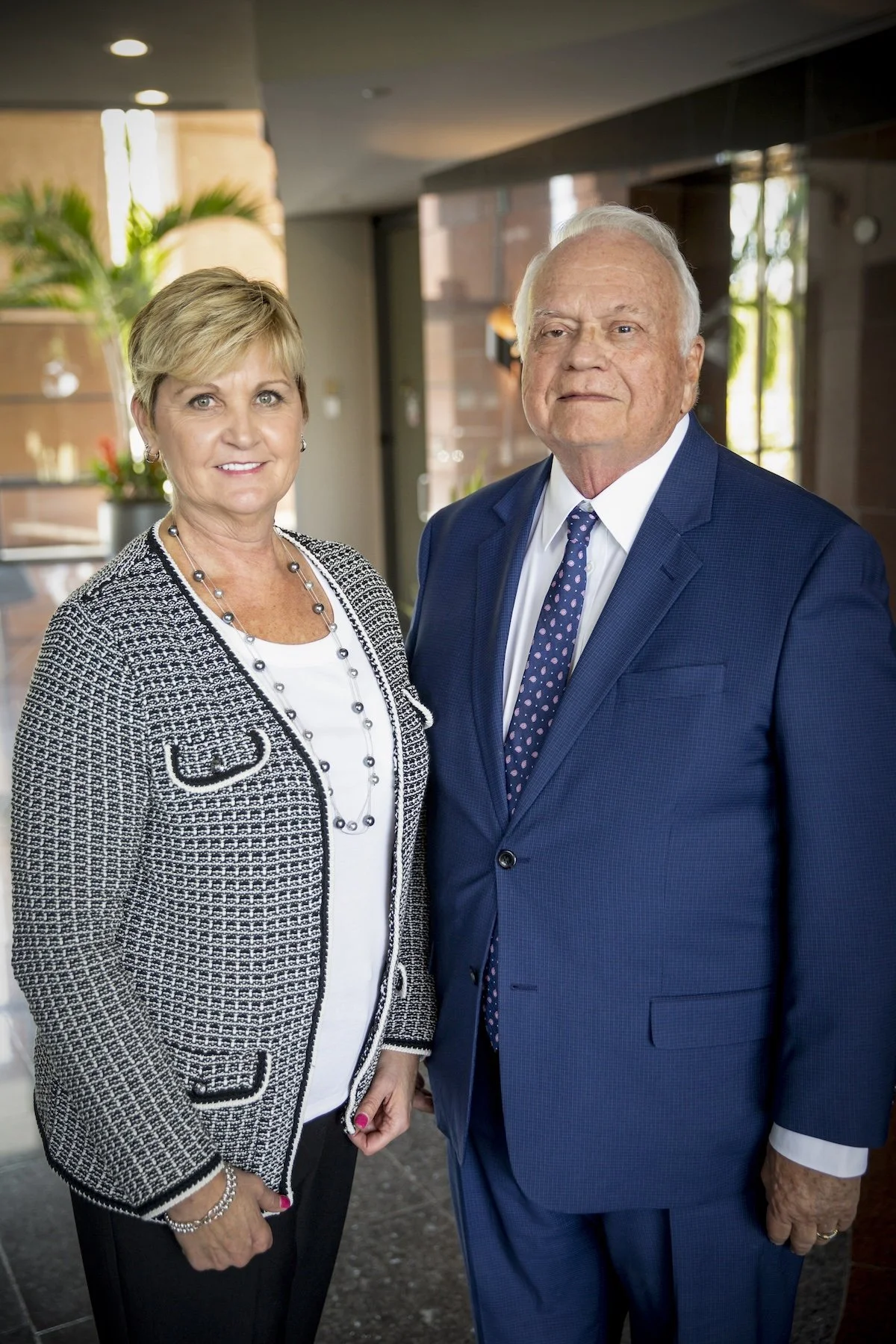 Woman and man in business attire standing in modern lobby