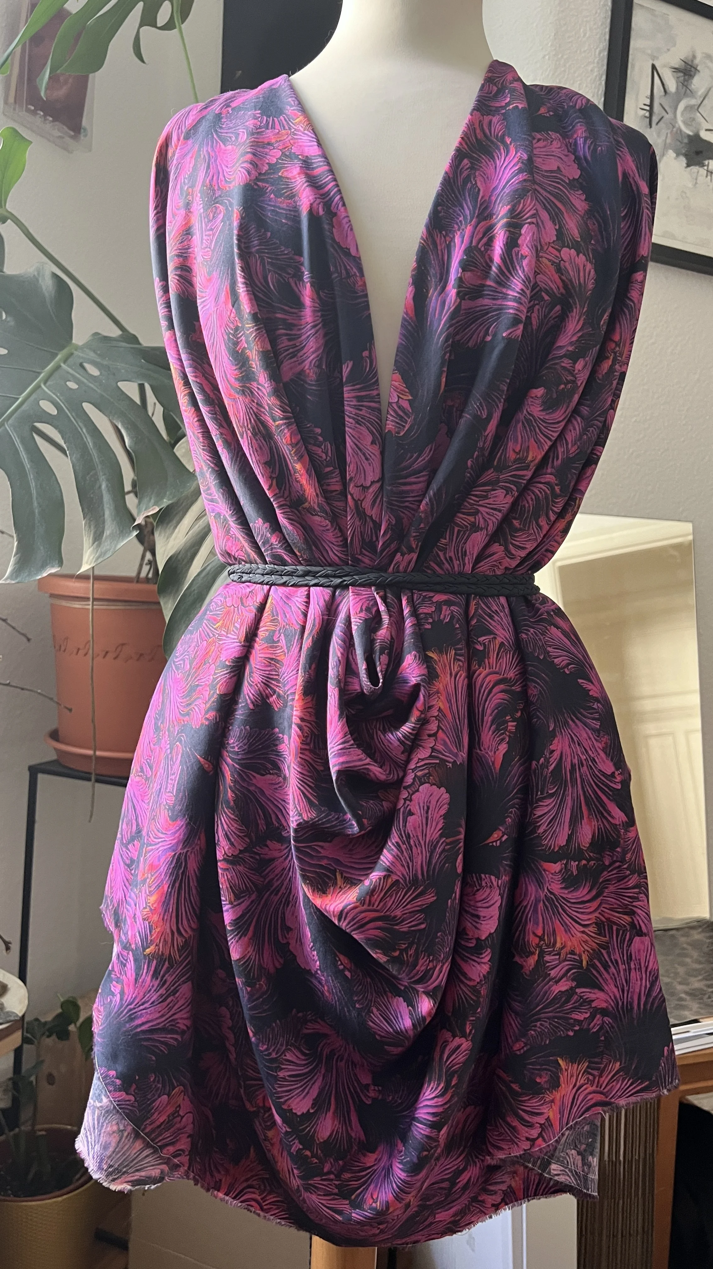 A vibrant dress with a purple and black floral pattern that is actually split gill mushrooms patterned by artist Shhhroooms. 
