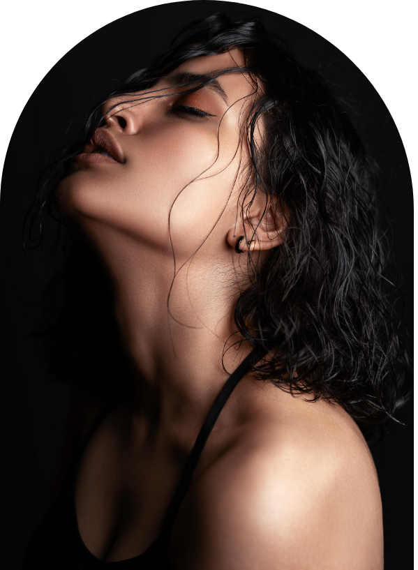 Close-up of a person with wet hair, head tilted back, eyes closed, and wearing a dark top.