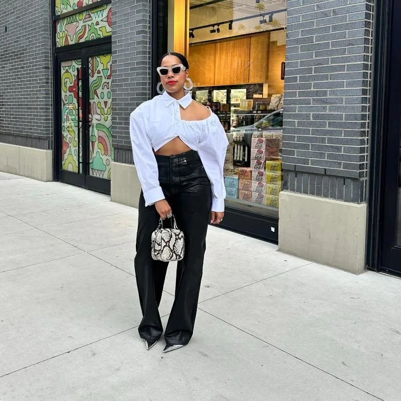 Chanel Tyler posing on street in white top and black pants