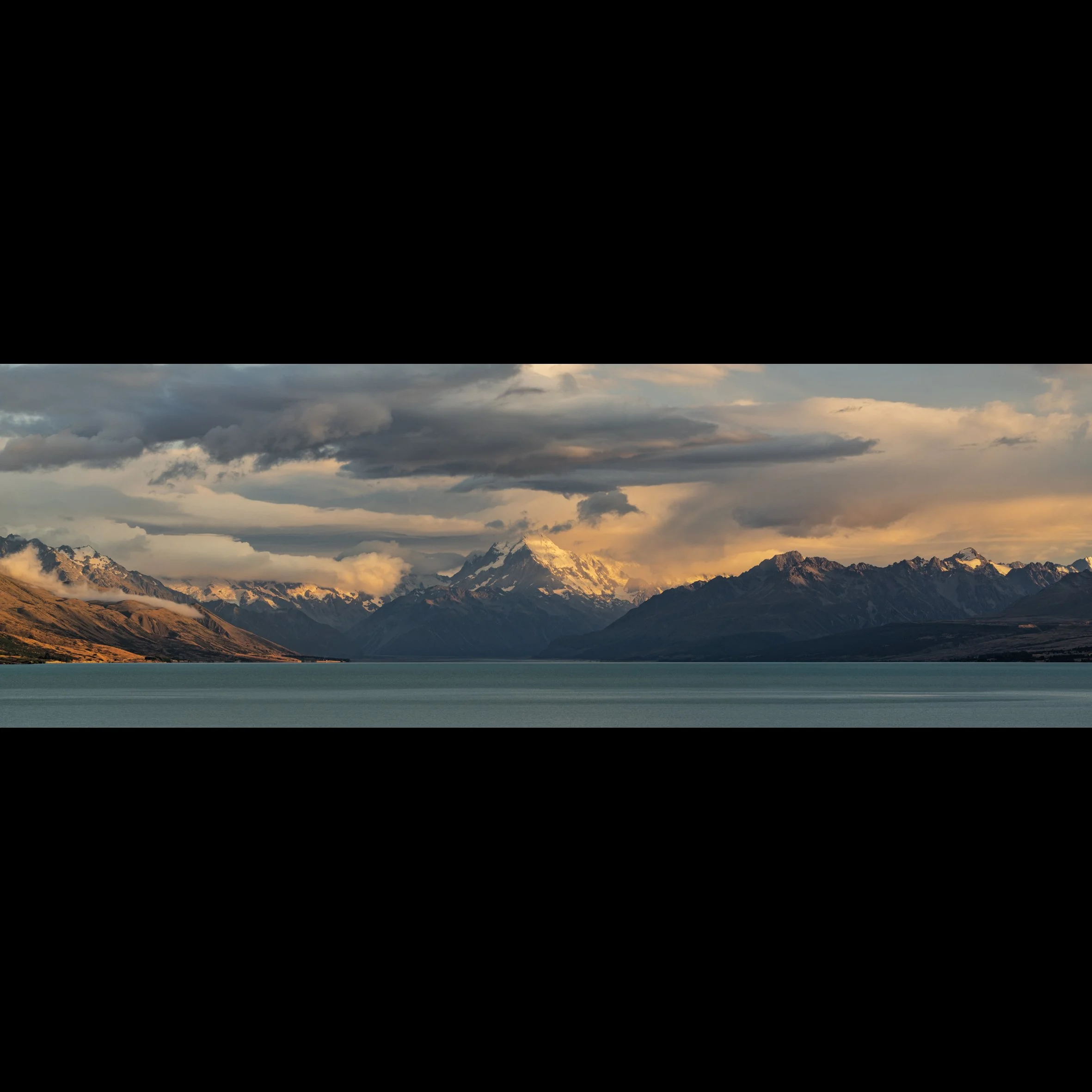 Golden hour on the shores of Lake Pukaki on a stormy morning looking towards Aoraki/Mt. Cook