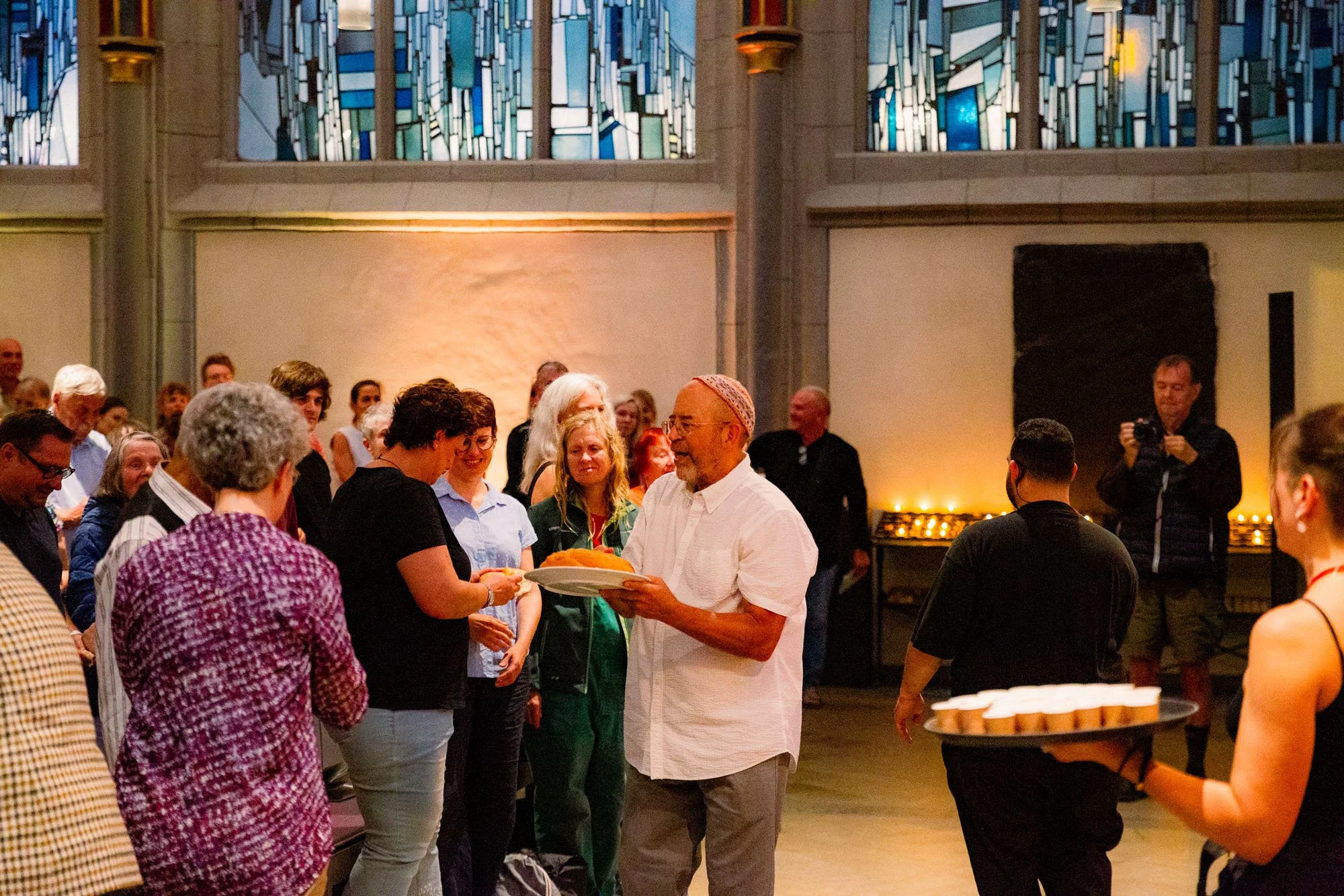 Ein Moment des Teilens: Rabbi Jonathan Kligler reicht das Challah-Brot beim Open Shabbat in die Reihen der Antoniterkirche. Foto: Kay-Uwe Fischer / SHALOM-MUSIK.KOELN