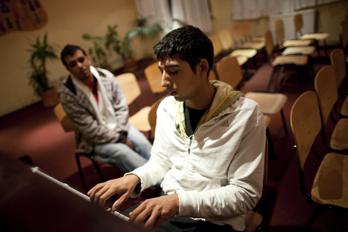  Ali plays piano at the Lazarus Centre for homeless youth in Bucharest, Romania. 