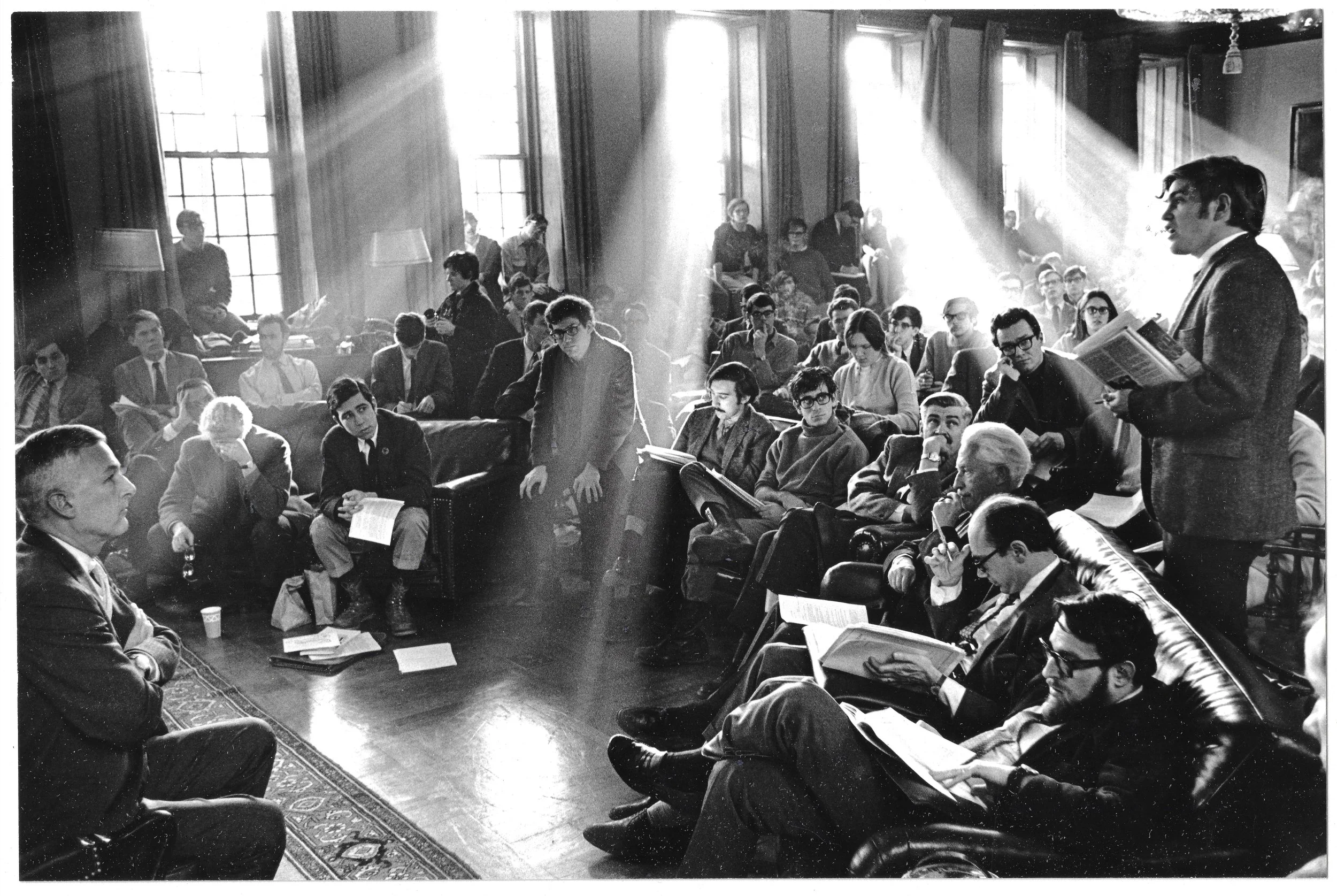 Student-Faculty Advisory committee meeting in the Lowell House common room, Spring 1969, to discuss divestment in South Africa with Harvard President Nathan L. Pusey at left and from right: Professors Martin Peretz, Stanley Hoffman, Erik Erikson  