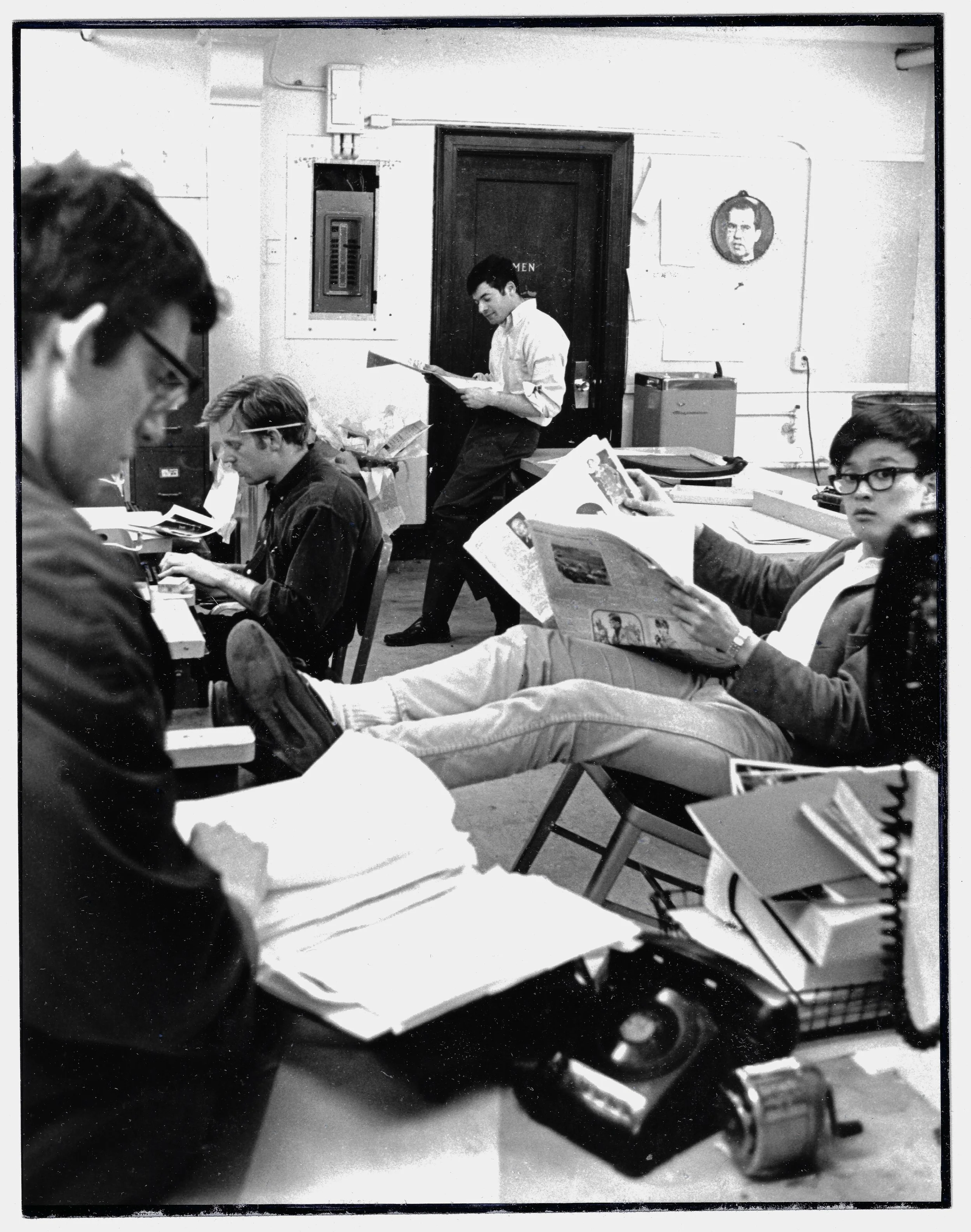 A NIxon dartboard next to the watercooler at the Harvard Crimson newsroom, with photo editors Wei Chu at right and Julian Levy on the typewriter. 