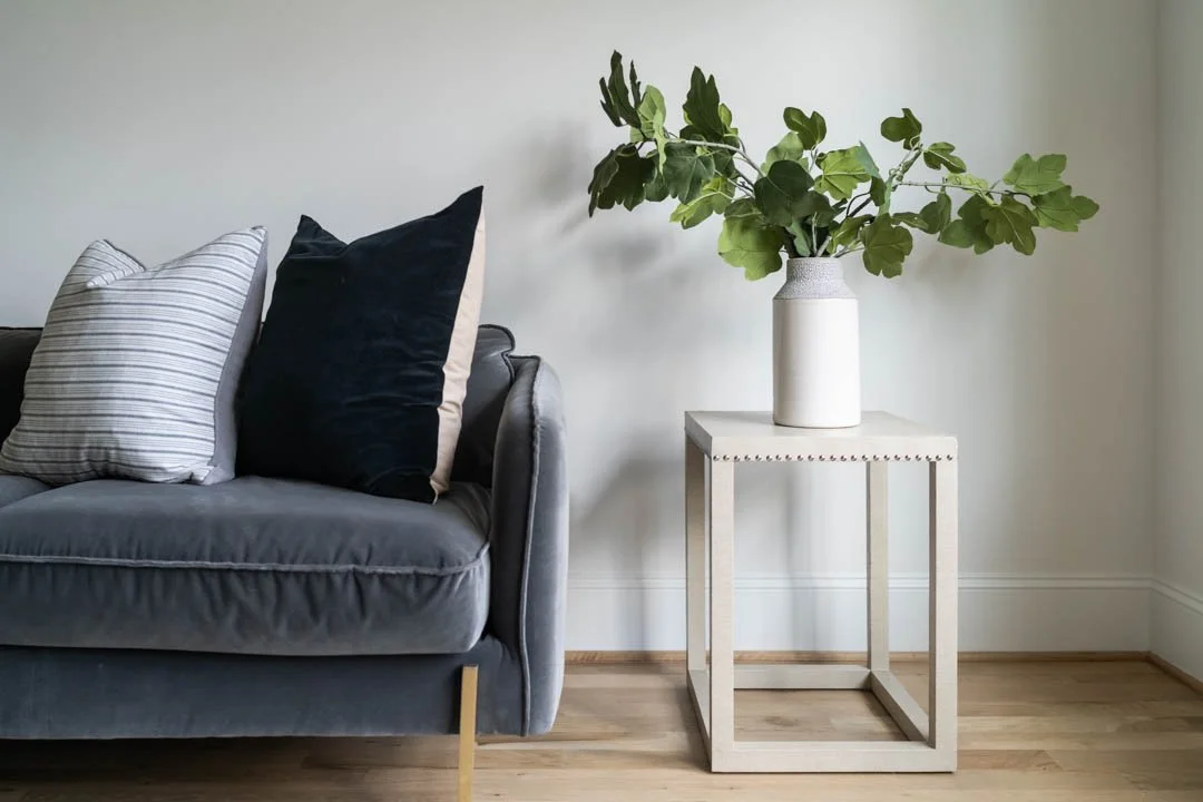 An interior photograph of a living room vignette with a modern blue couch.