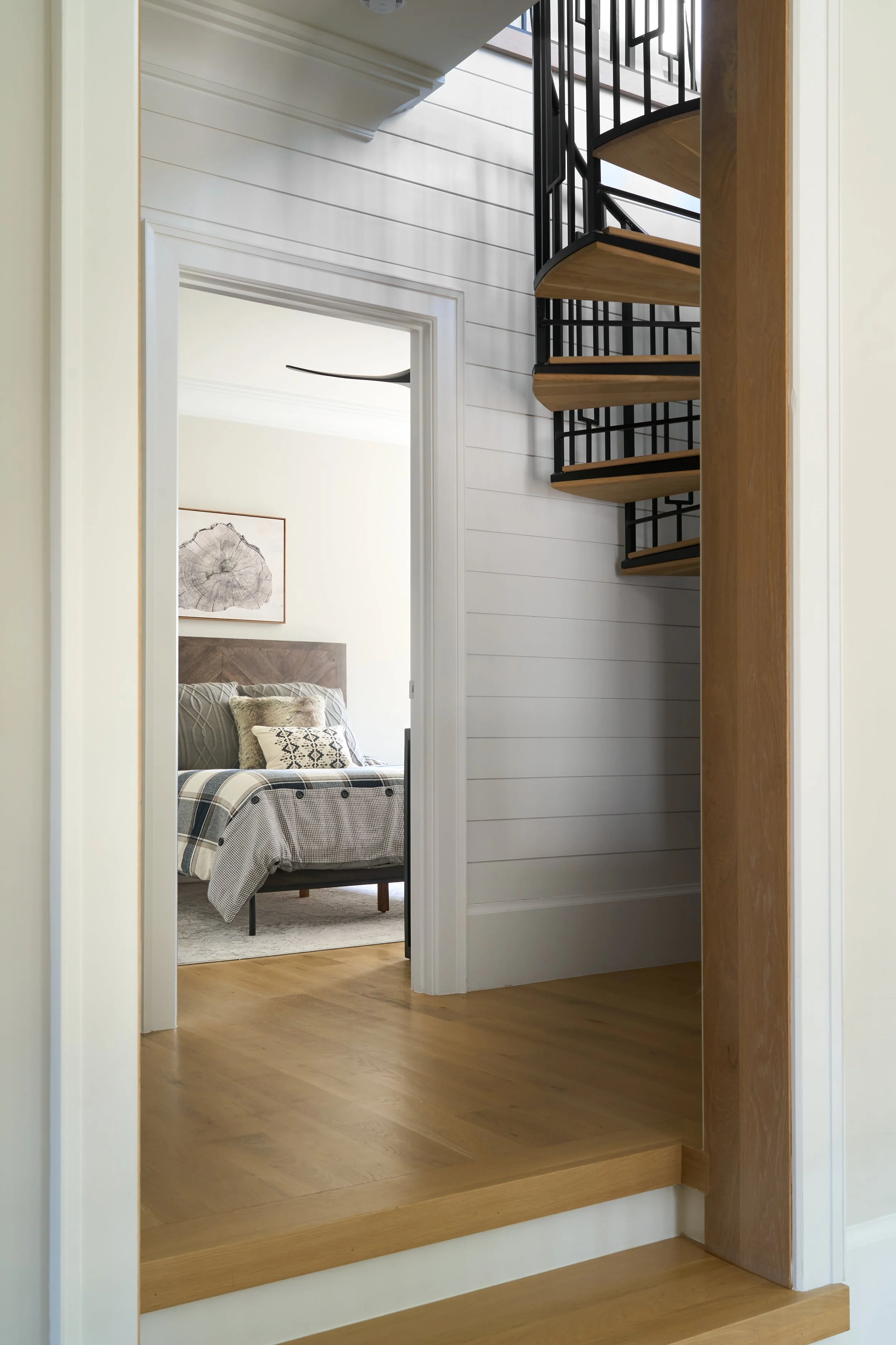 peeking into a bedroom with a circular stair case in outside hallway 