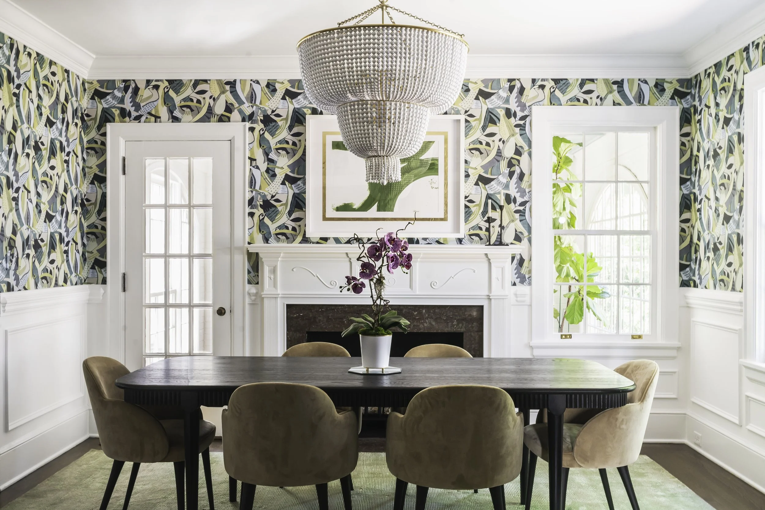 Interior photography of a dining room with blue and green bird wallpaper.