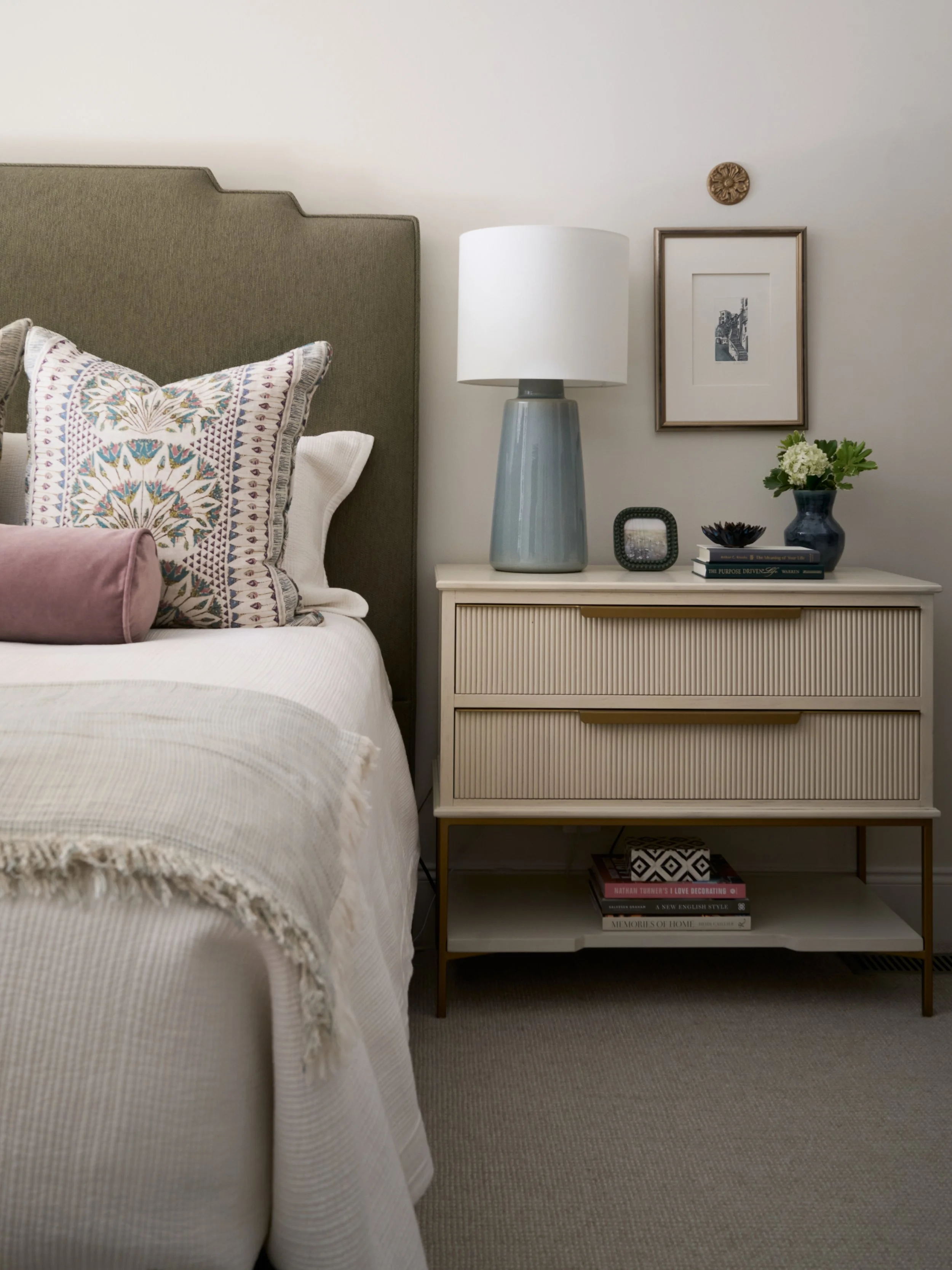 image of a master bedroom in calming, neutral colors with a pop of pink in an accent pillow