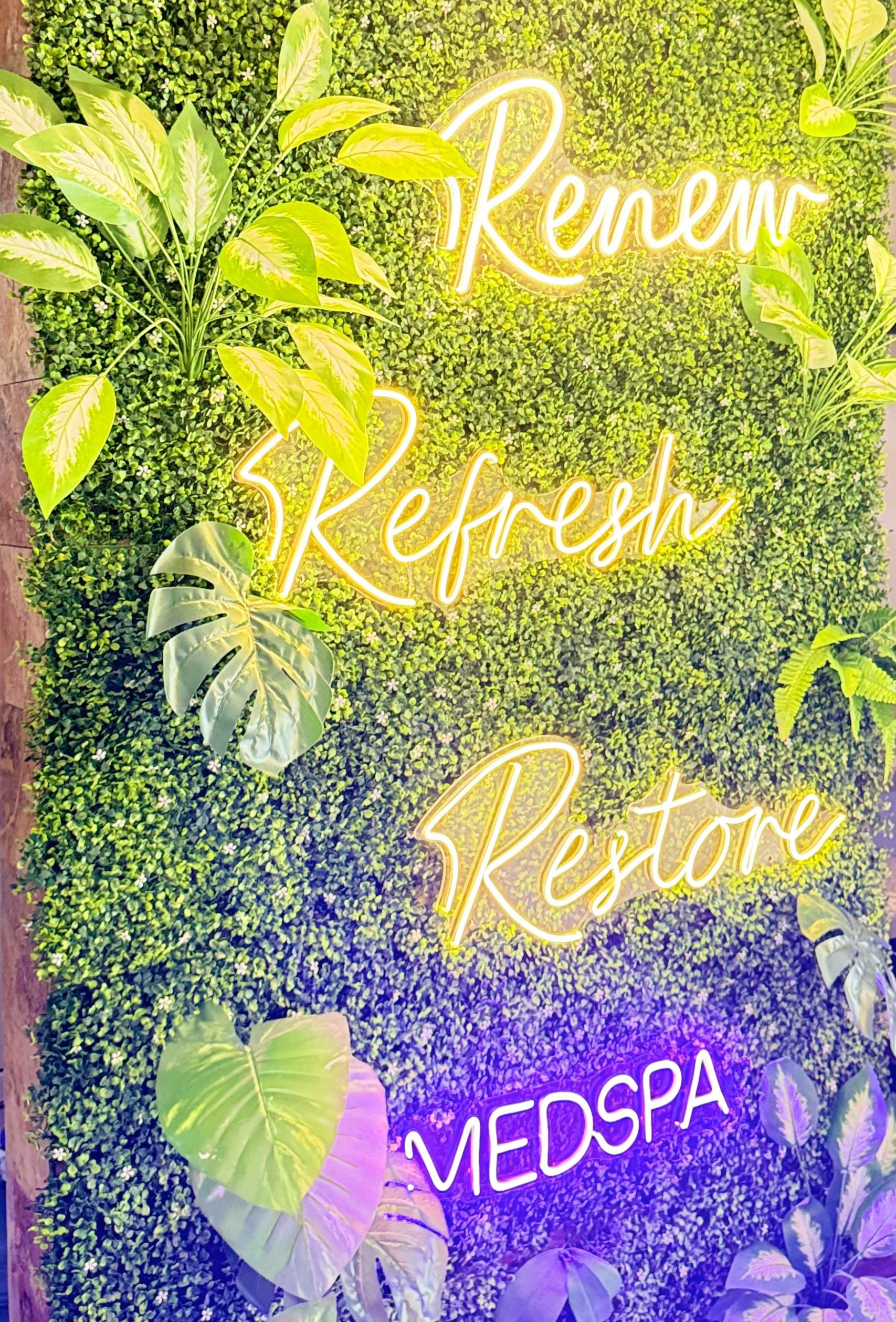 Mural de pared con plantas verdes y neón que dice 'Keren', 'Refresh', y 'Medspa'.