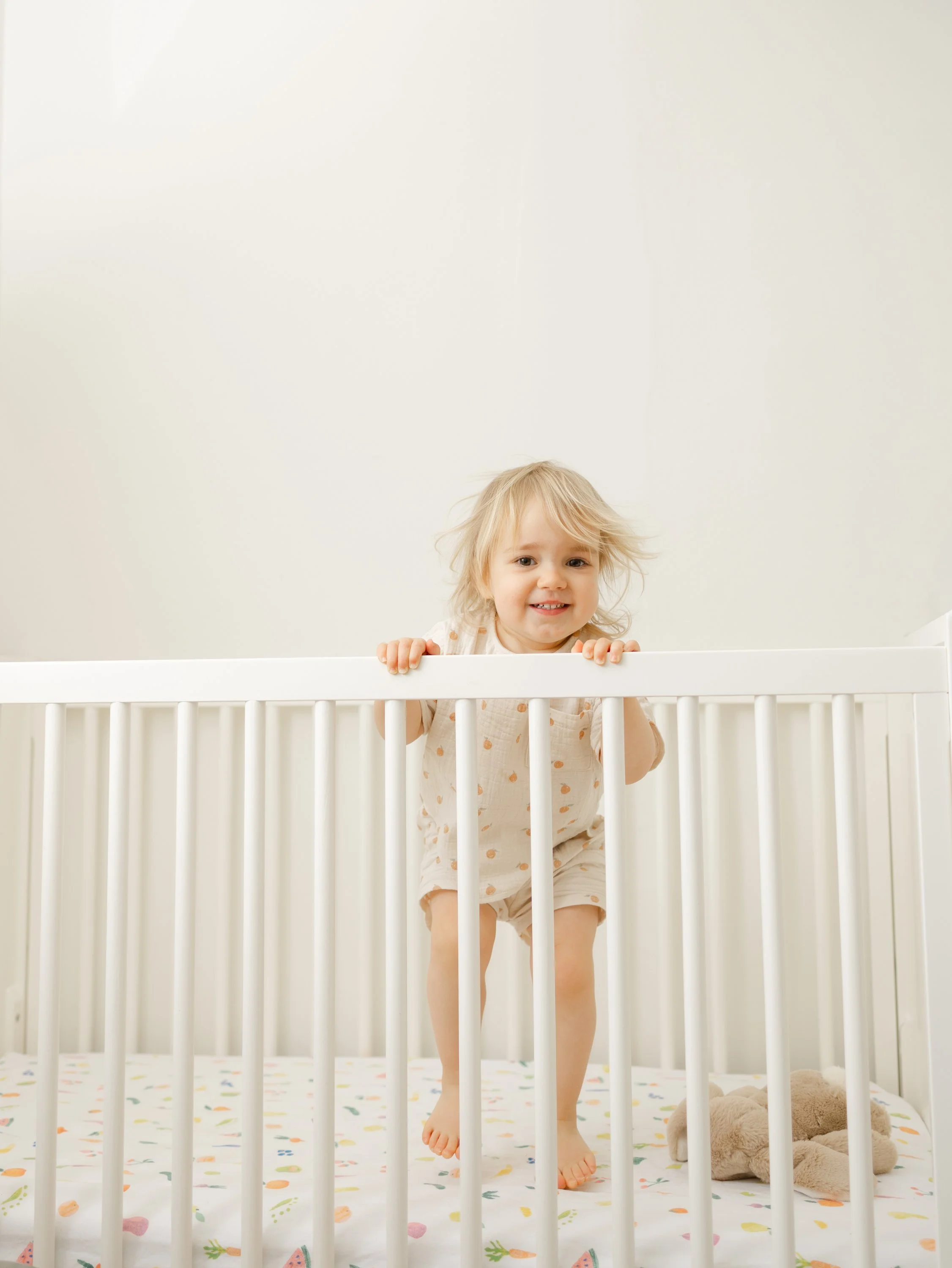 Lifestyle photo of child playing in crib captured with off camera flash