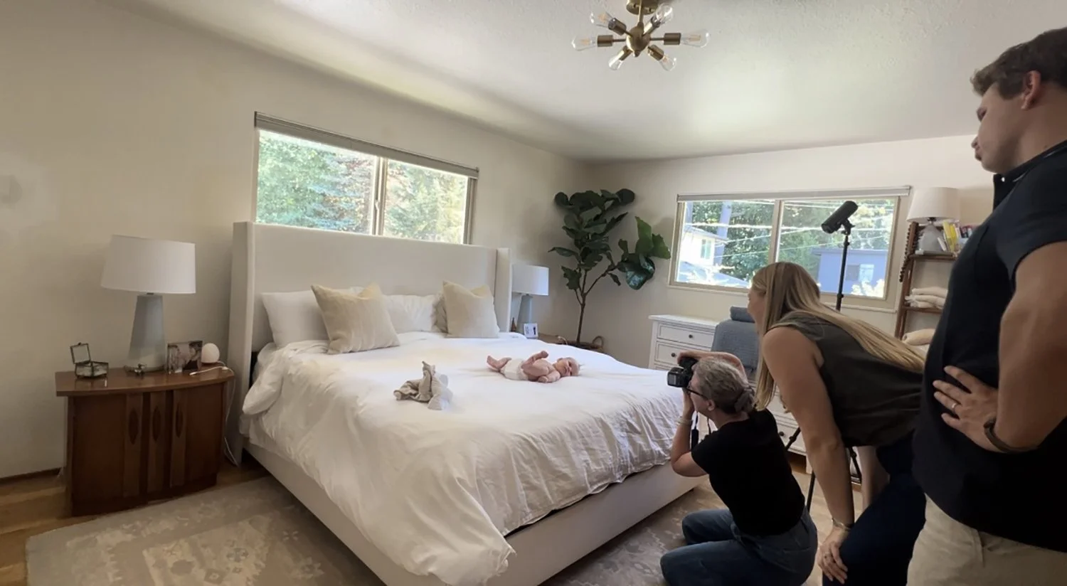 Photographer using a flash to photograph a baby in their home.