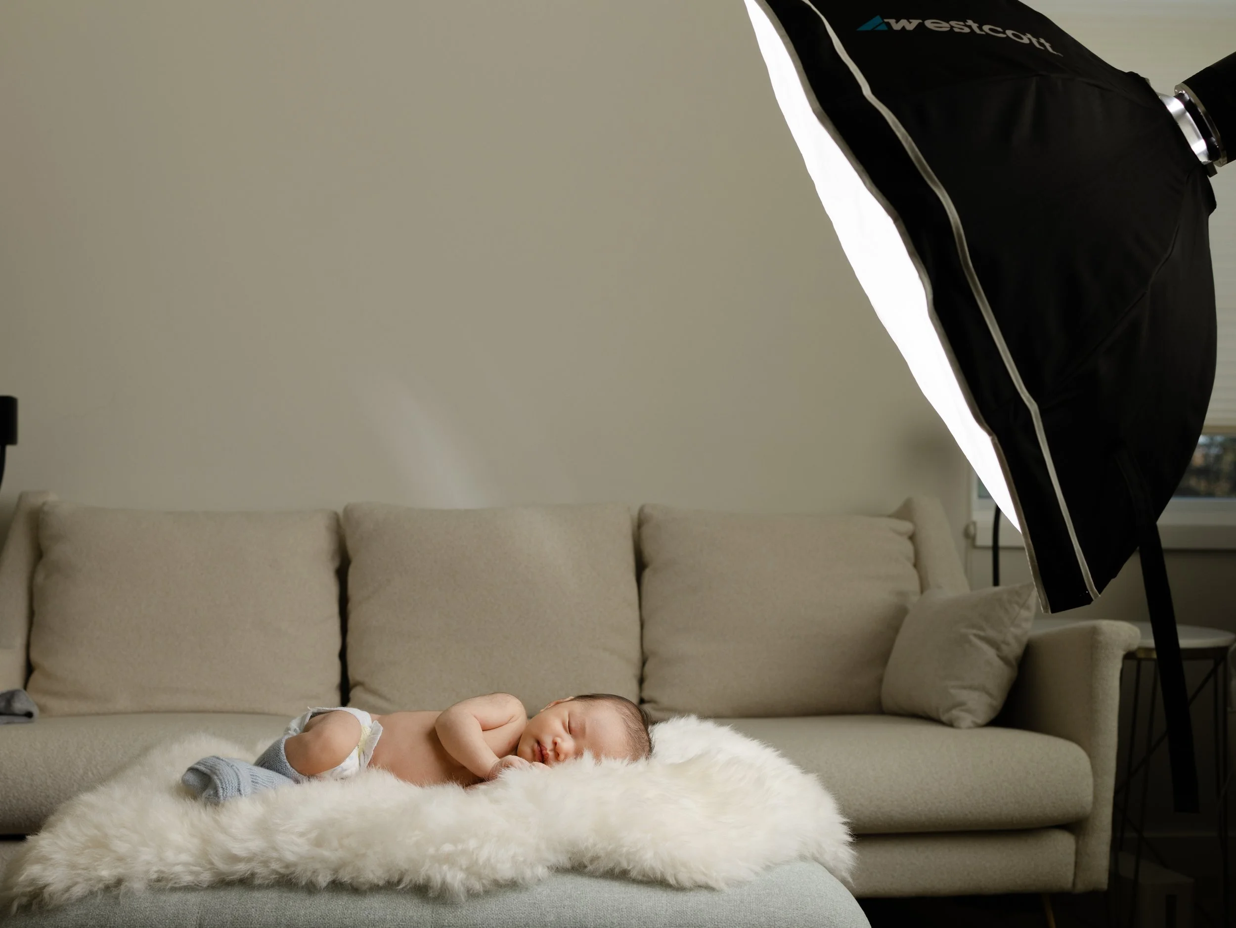 Newborn sleeping in-home lit by one flash on a stand