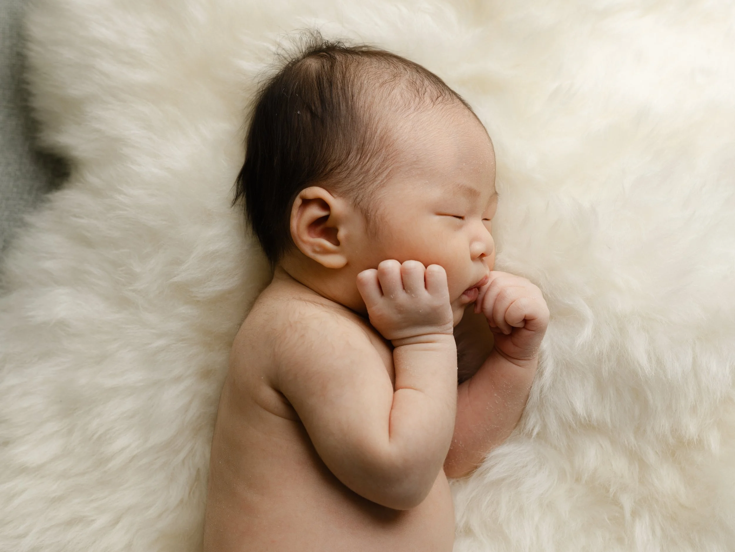 sleeping newborn photographed using off camera flash in a client's home