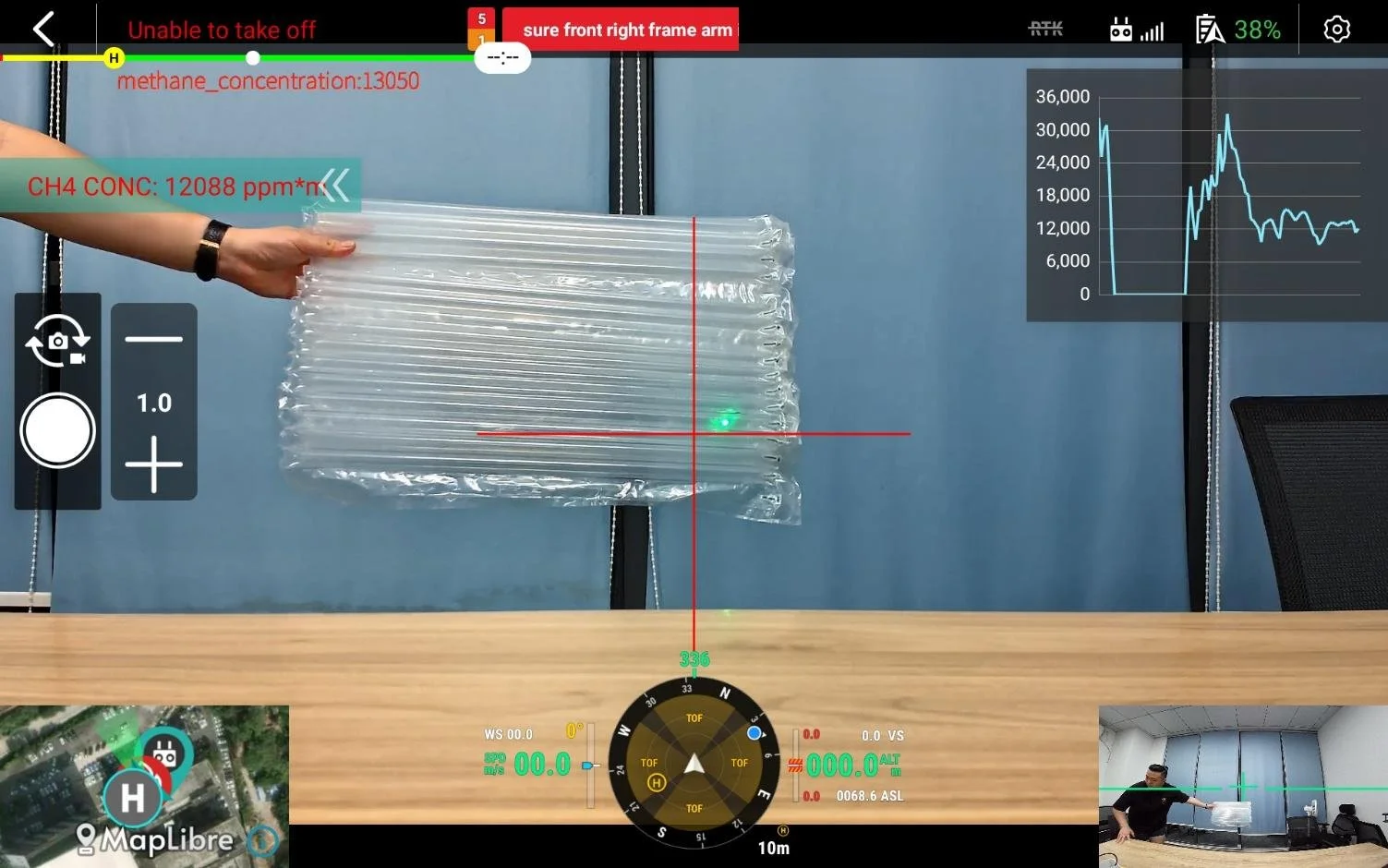 Individual grasping a plastic bag filled with methane, captured and monitored on screen showing live methane leak monitoring in a laboratory
