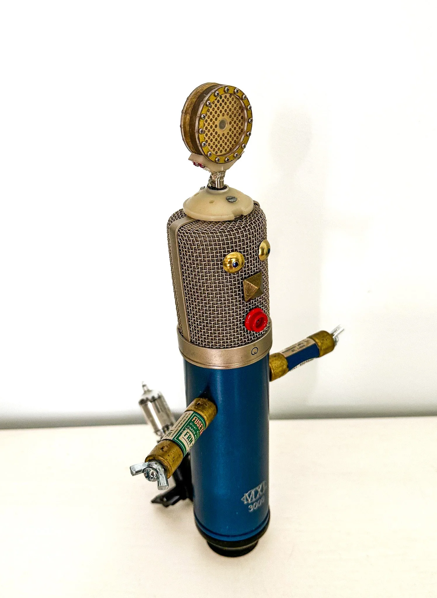 AVAILABLE: "Mike, the Emcee"
11 X 7 X 5
Hi, I’m Mike… Wait! Please don’t drop me!! I’ve been dropped
so many times I think I’m going to go crazy!
Constructed from a deconstructed old MXL 3000 condenser microphone, old fuses, a vacuum tube, furnitu