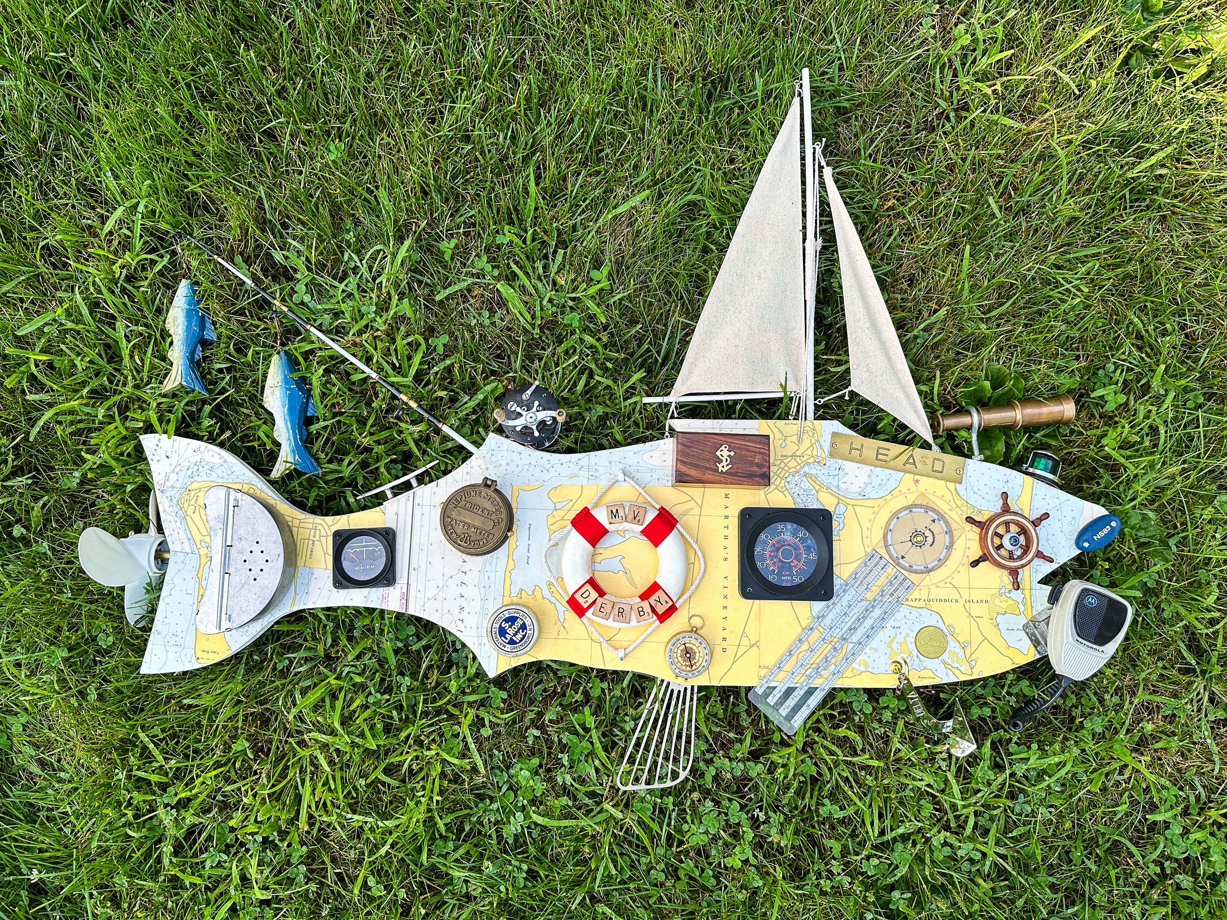 SOLD "Nauti-Bass"
45"W X 33"T X 6"D. Constructed on the wooden bass base with a vintage map of Martha's Vineyard, sail from a toy sailboat, brass telescope, keychain fender, toy ships wheel, doll eye, old marine radio microphone, promotional Delta a