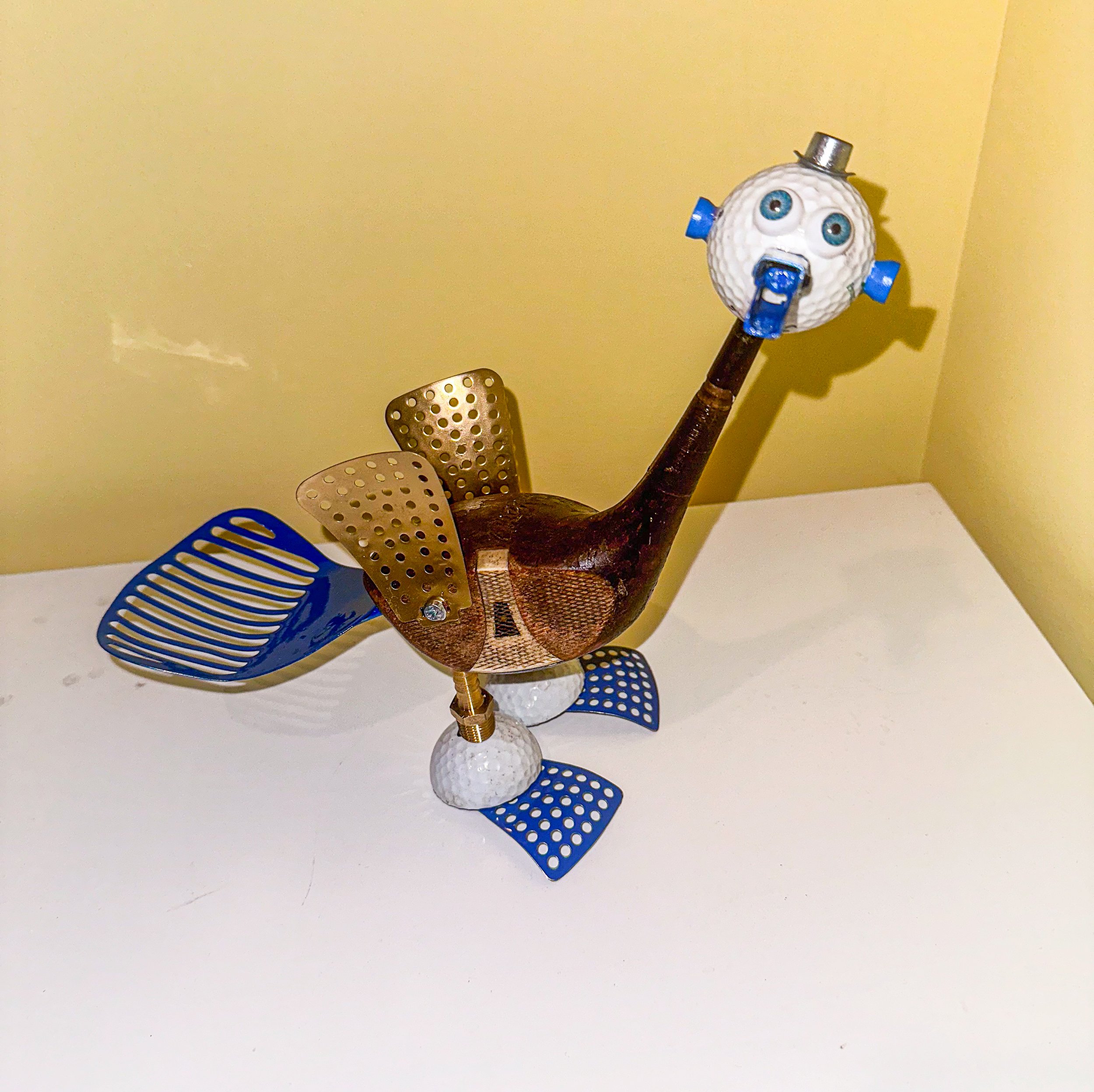 SOLD. “Bubba Birdie” aka “The Golfer’s Talisman”
Vintage wooden driver, golf balls, golf tees, vegetable steamer leaves, vintage frying strainer, brass hose barb connectors, toggle bolt, doll eyes, monopoly piece.
Bubba Birdie has quite the pedigre