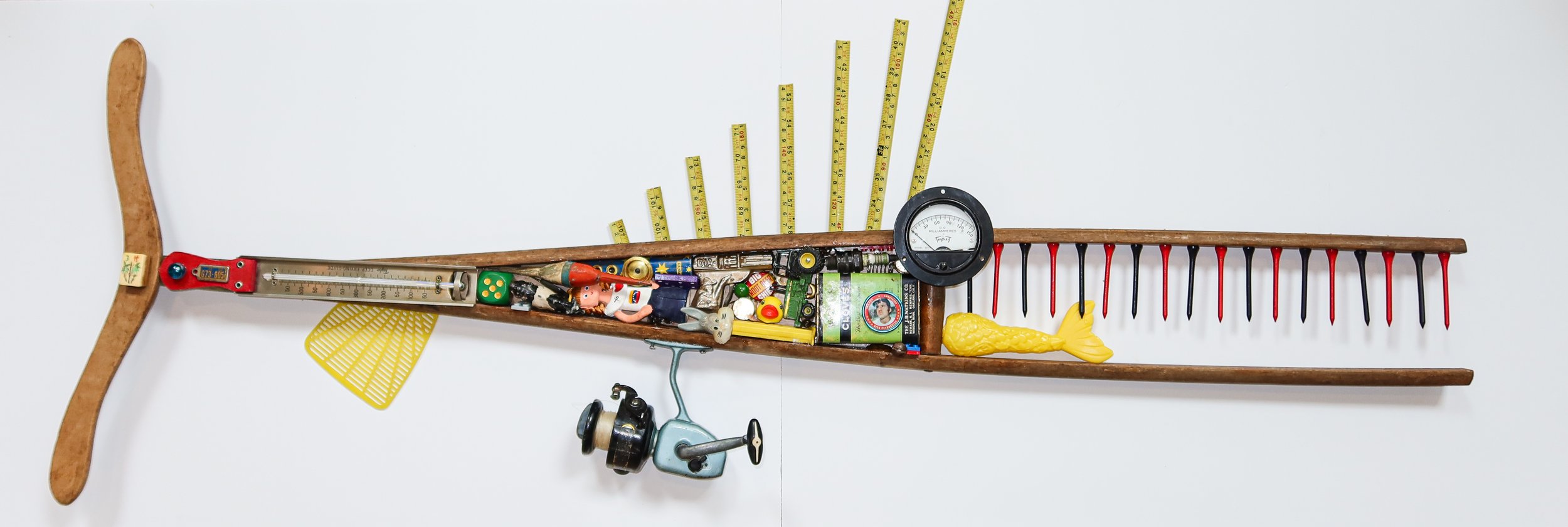 SOLD. Found Fish #9; "Marlin Monroe". Antique civil war wooden crutch, amp meter, hanger, toys, measuring tape, vintage fishing reel.
52"W X 20"T X 4"D.