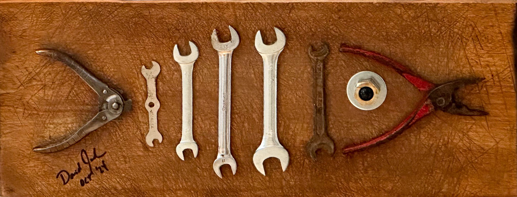 AVAILABLE. "Toolfish 2".
Part of an old well-used cutting board, vintage pliers, vintage wire cutter, old wrenches, steel washer, brass nut, marble.
8" X 20" X 2"