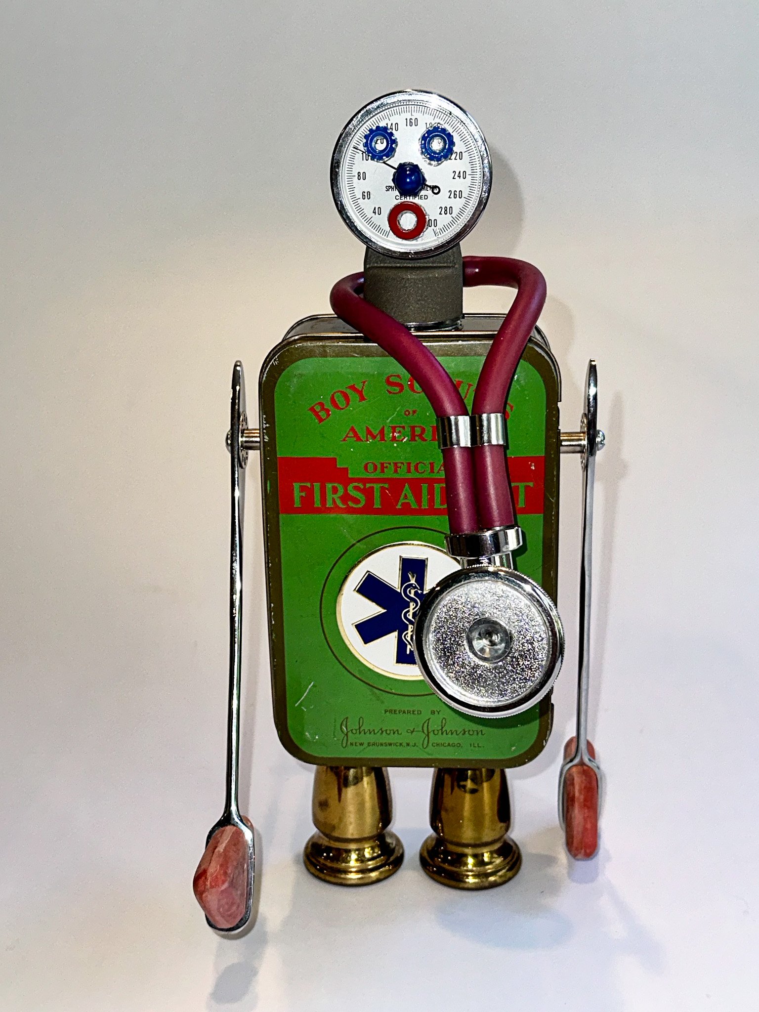 AVAILABLE.
"Dr Yuul B. Fine"
12" X 6" X 6"
Vintage 1940’s Boy Scouts first aid kit, reflex hammers, manometer, vintage antiseptic tin, stethoscope, brass parts from a vintage chandelier, hardware.