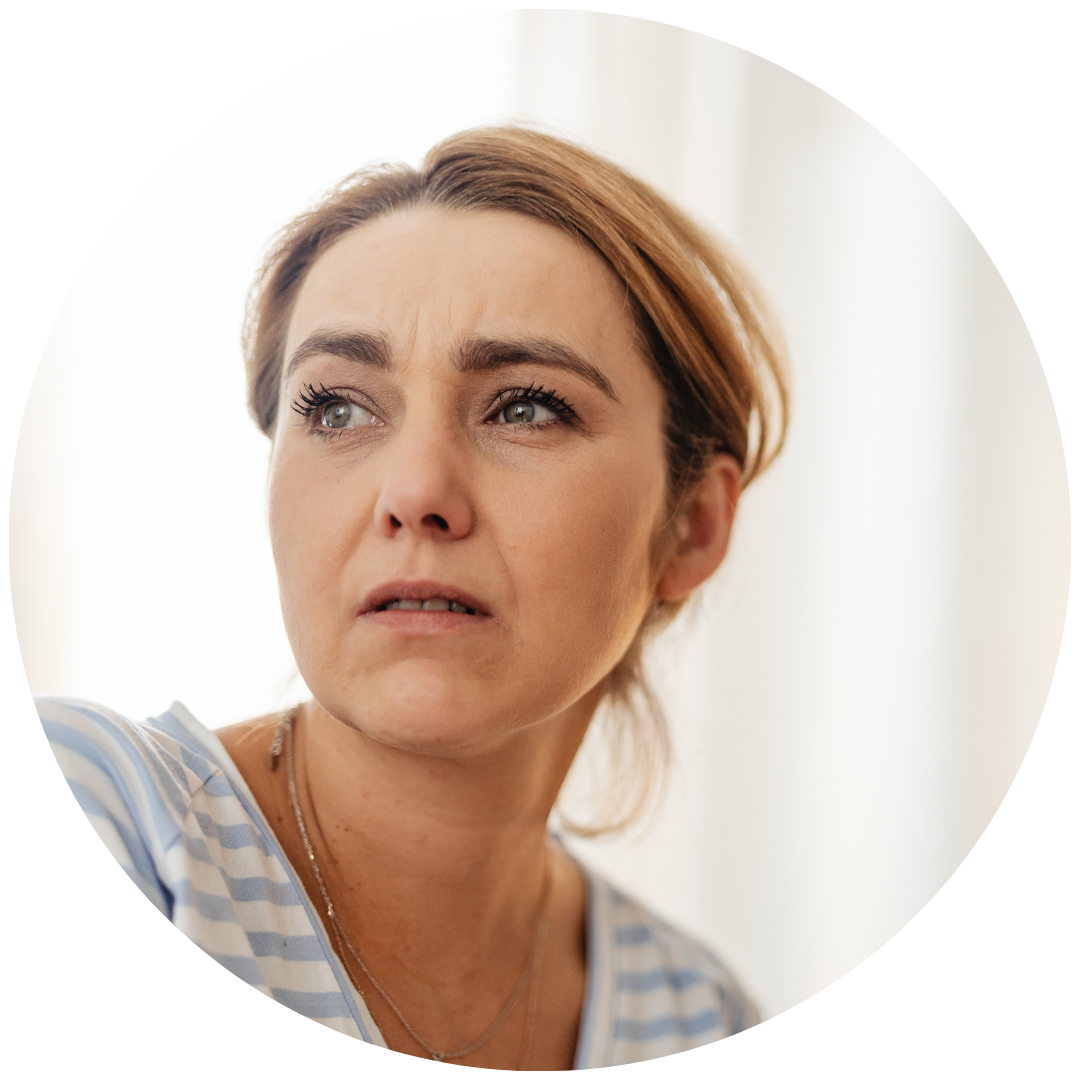 A woman with short, reddish-brown hair looking to her left with a concerned or confused expression.