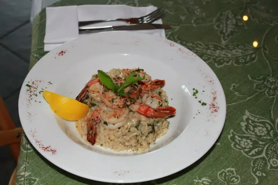 plate of risotto with shrimp and lemon.