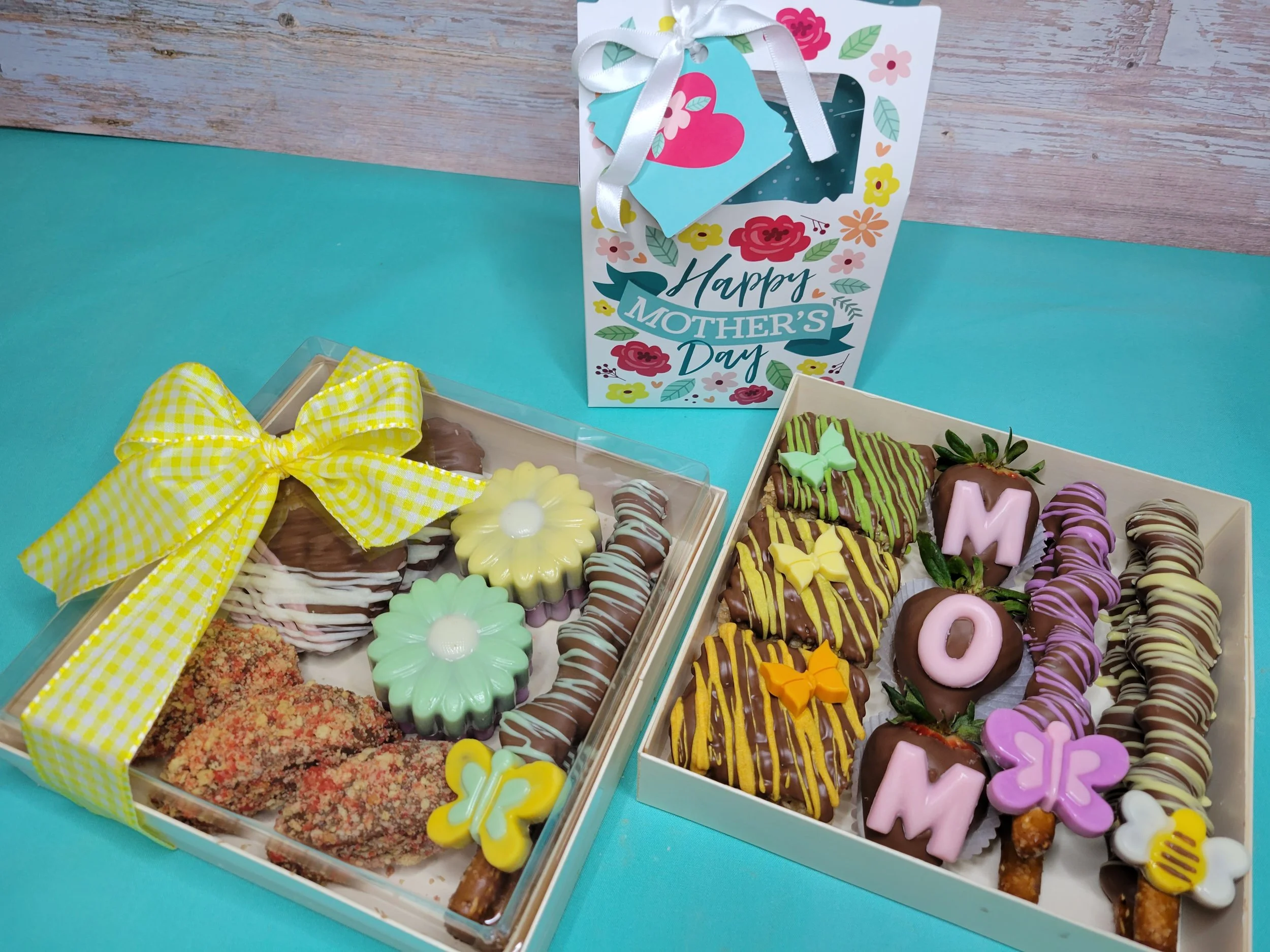 A gourmet goodie box filled with assorted chocolate-covered strawberries and chocolate-coated stuffed pretzels, decorated for spring including colorful drizzle, sprinkles and butterflies in a gift box with a 'Happy Easter' ribbon.