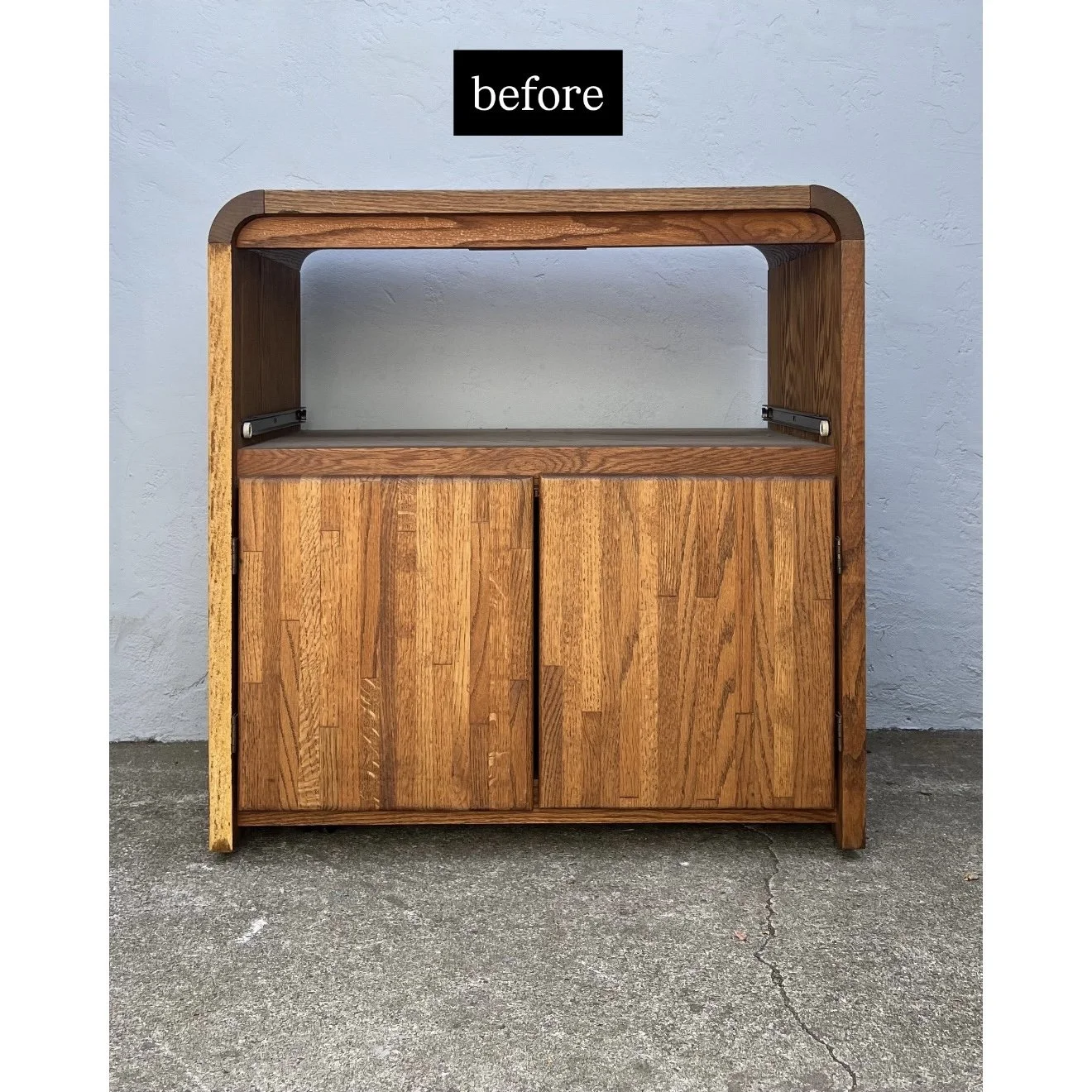 Wooden cabinet with two doors, open top shelf, set against a light-colored wall, on concrete ground, labeled 'before' at the top.
