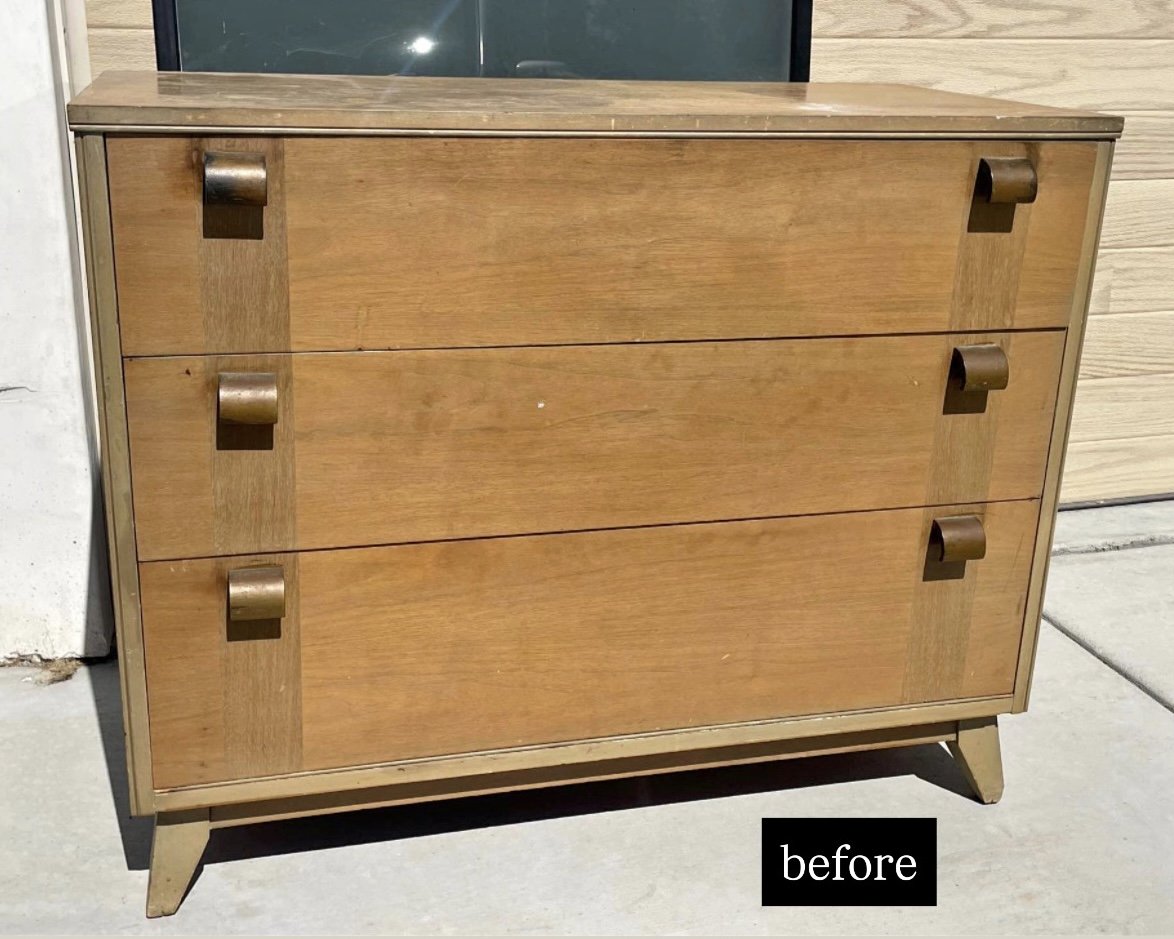 Wooden dresser with three drawers, each with brown handles, placed outside on pavement near a wall and window, labeled 'before'.