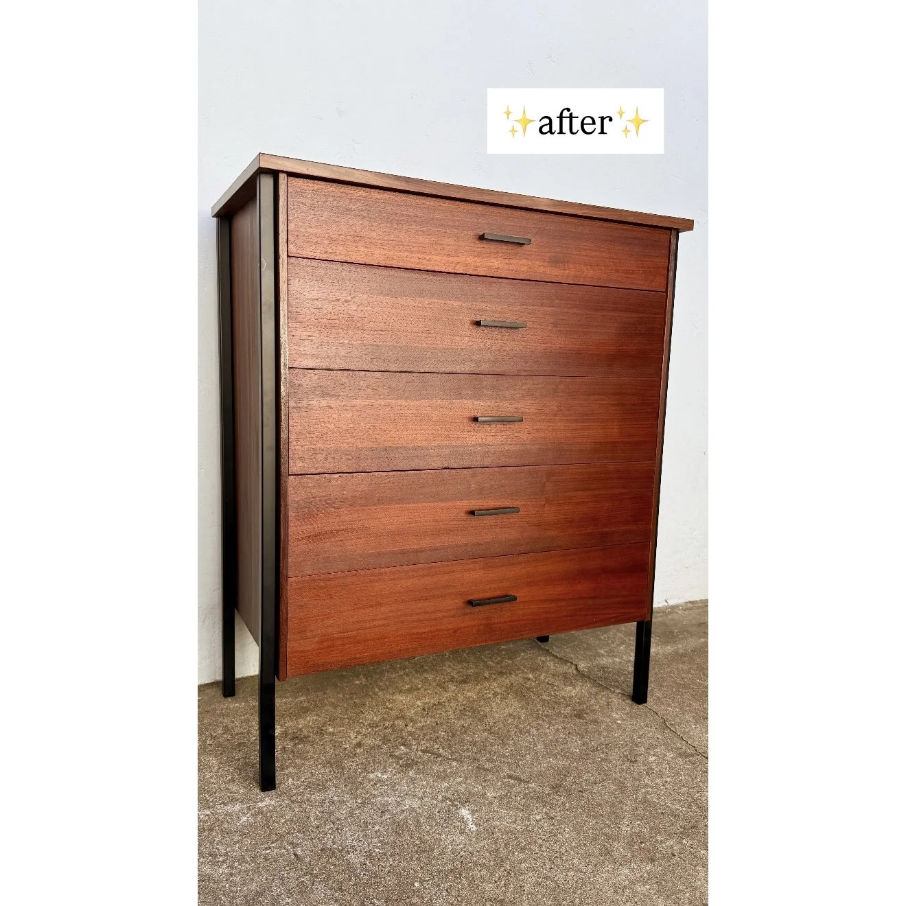 A wooden chest of drawers with five drawers and black handles, standing on black metal legs against a white wall. The photo has the word 'after' with sparkles above it.