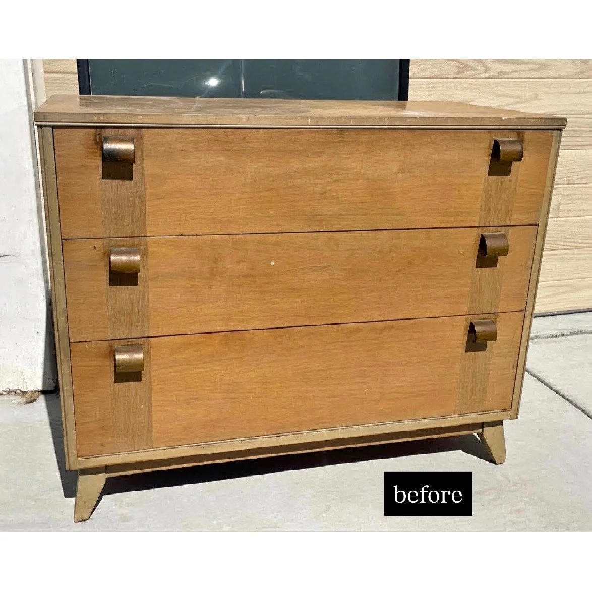 A wooden dresser with three drawers and metallic handles, placed on a concrete floor outside, labeled 'before'.