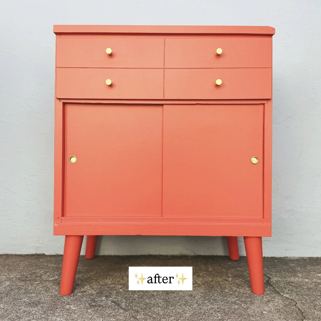 A pink wooden cabinet with four small golden knobs, standing on four angled legs against a plain white wall. The word 'after' is written below it.
