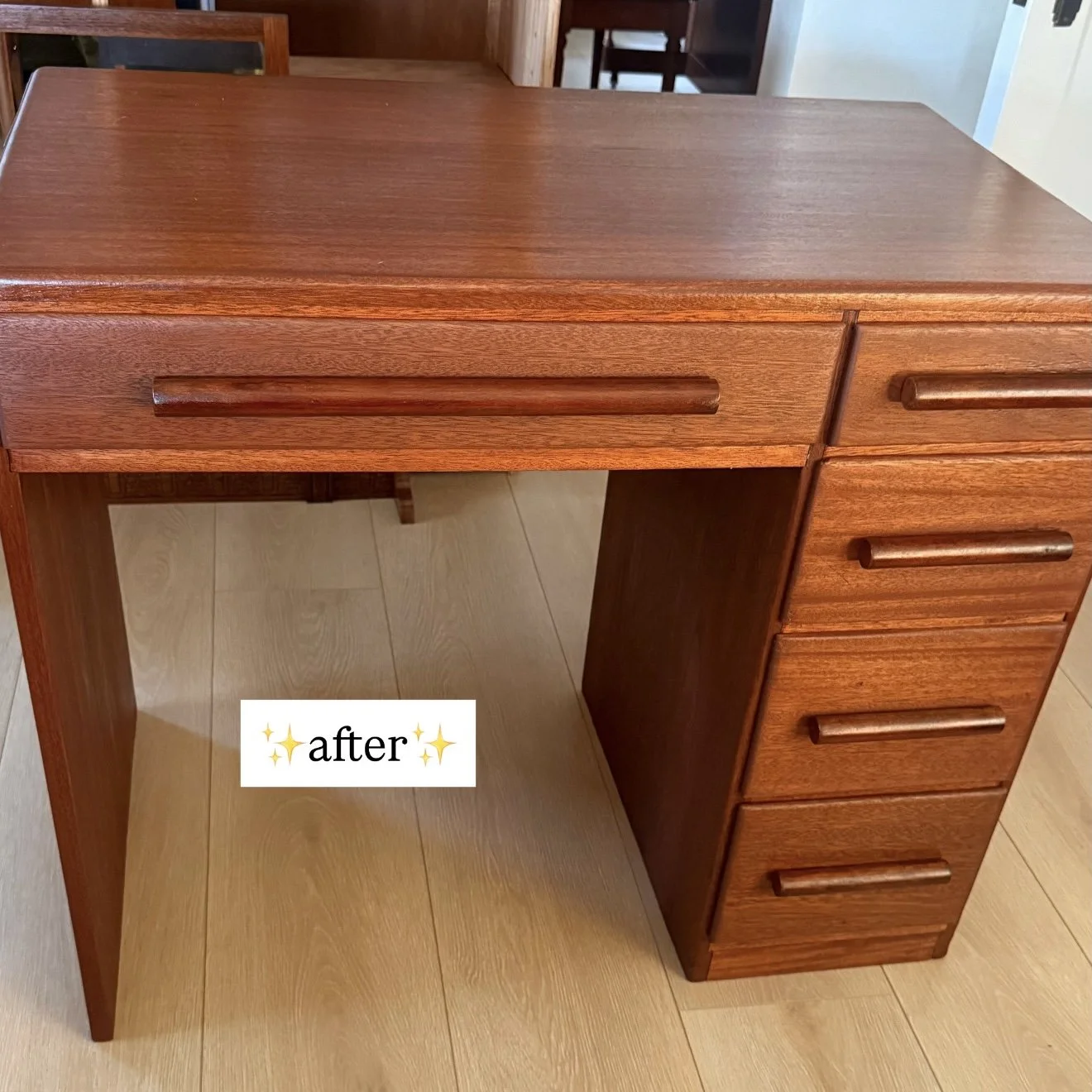 A wooden desk with five drawers on the right side and a smooth top surface. The desk is positioned on a light-colored wooden floor. The word 'after' with star emojis is overlaid on the bottom left side of the image.