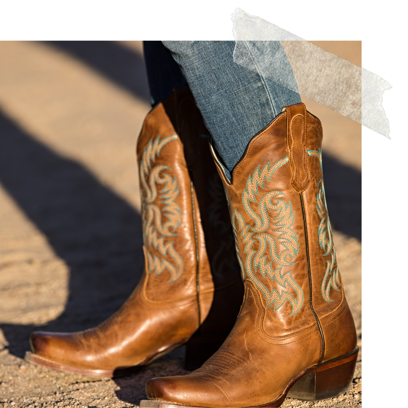 Brown cowboy boots with turquoise embroidery and blue jeans standing on a dirt road, capturing a grounded, everyday lifestyle moment