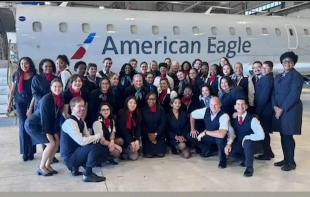 SkyWest Flight Attendants gathered together in front of an American Eagle jet