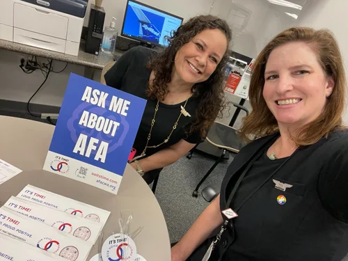 Two SkyWest Flight Attendants with an Ask Me About AFA sign