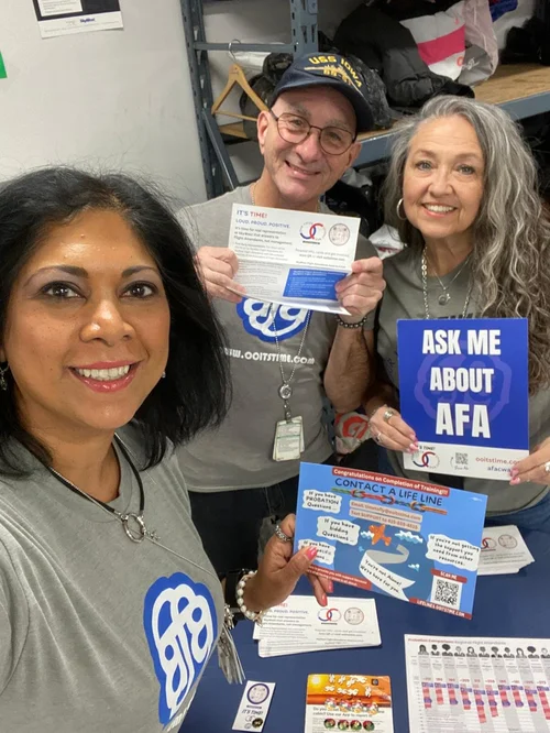 SkyWest Flight Attendants with Ask Me About AFA signs and cards