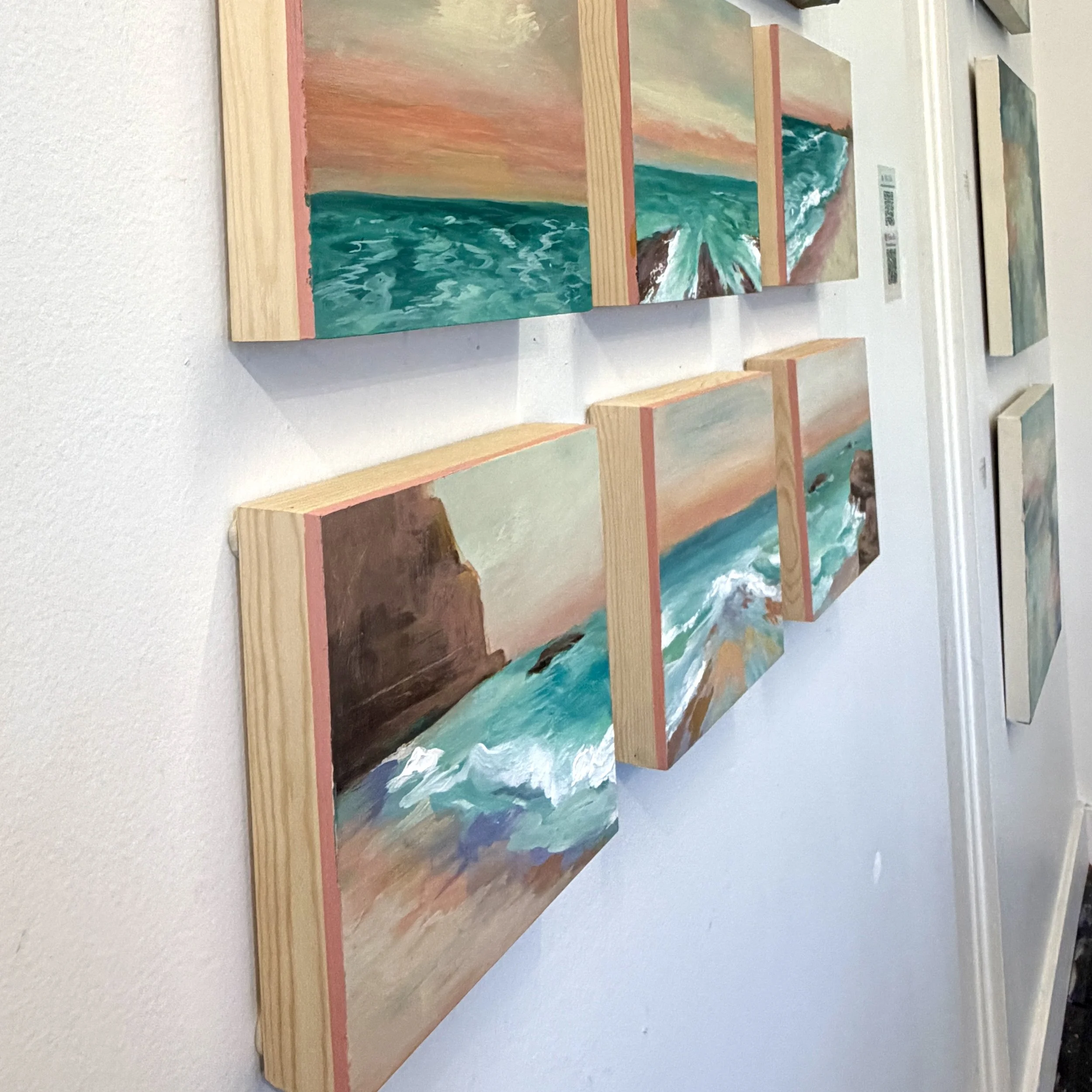 Gallery wall with seascape paintings